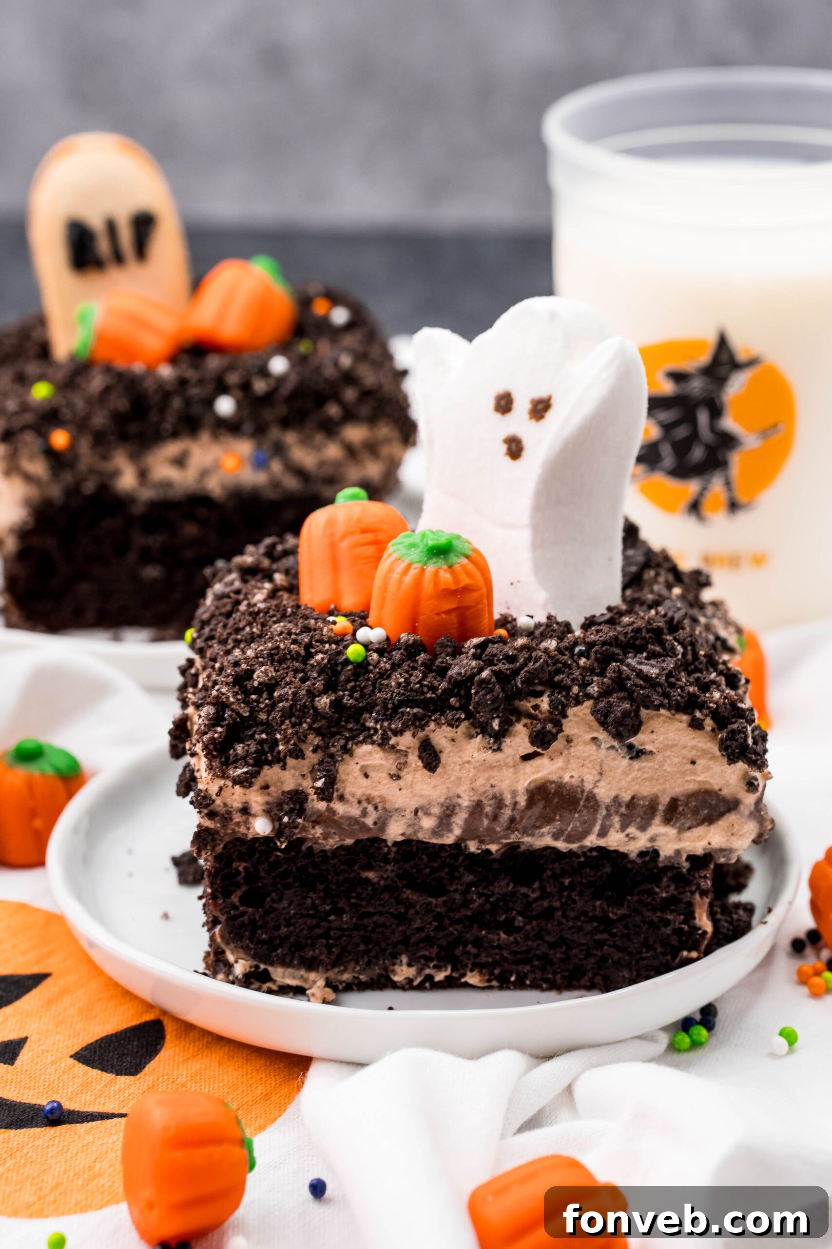 A tempting slice of Halloween Dirt Cake, showcasing its delightful layers and festive decorations, served on a pristine white plate.