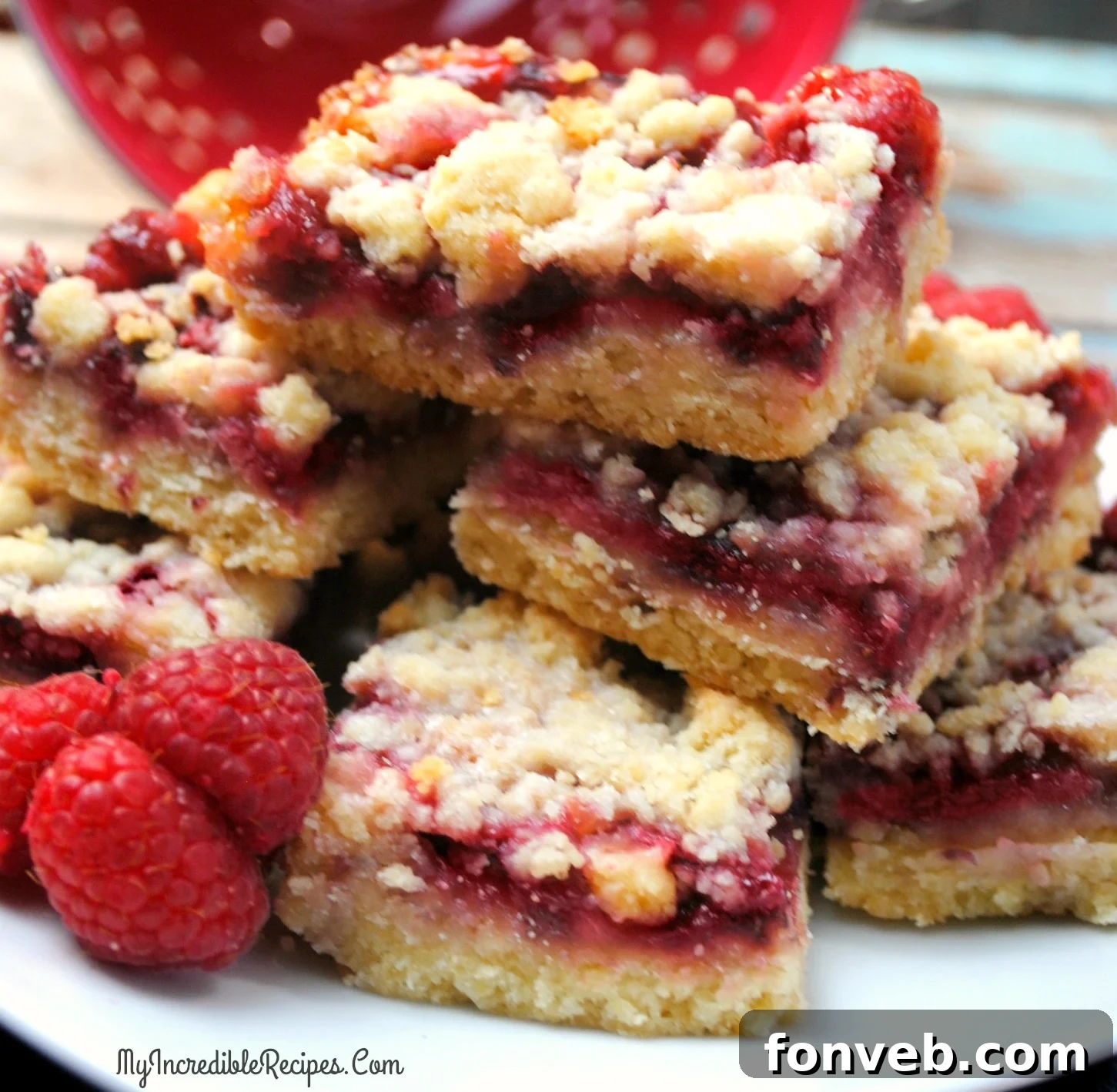 Jammy Raspberry Oat Bars 3 A bowl filled with fresh, ripe red raspberries, ready to be incorporated into the crumble bars.