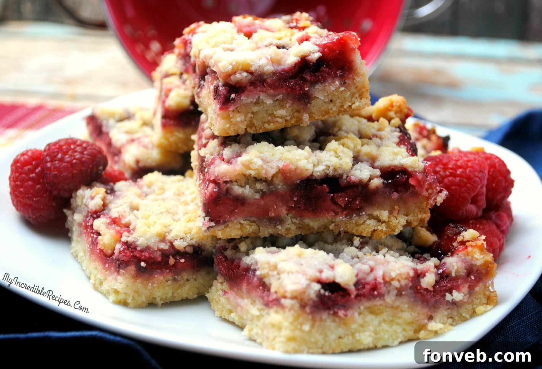Jammy Raspberry Oat Bars 7 Several raspberry crumble bars arranged artfully on a white surface, highlighting their crumbly texture and fruit filling.