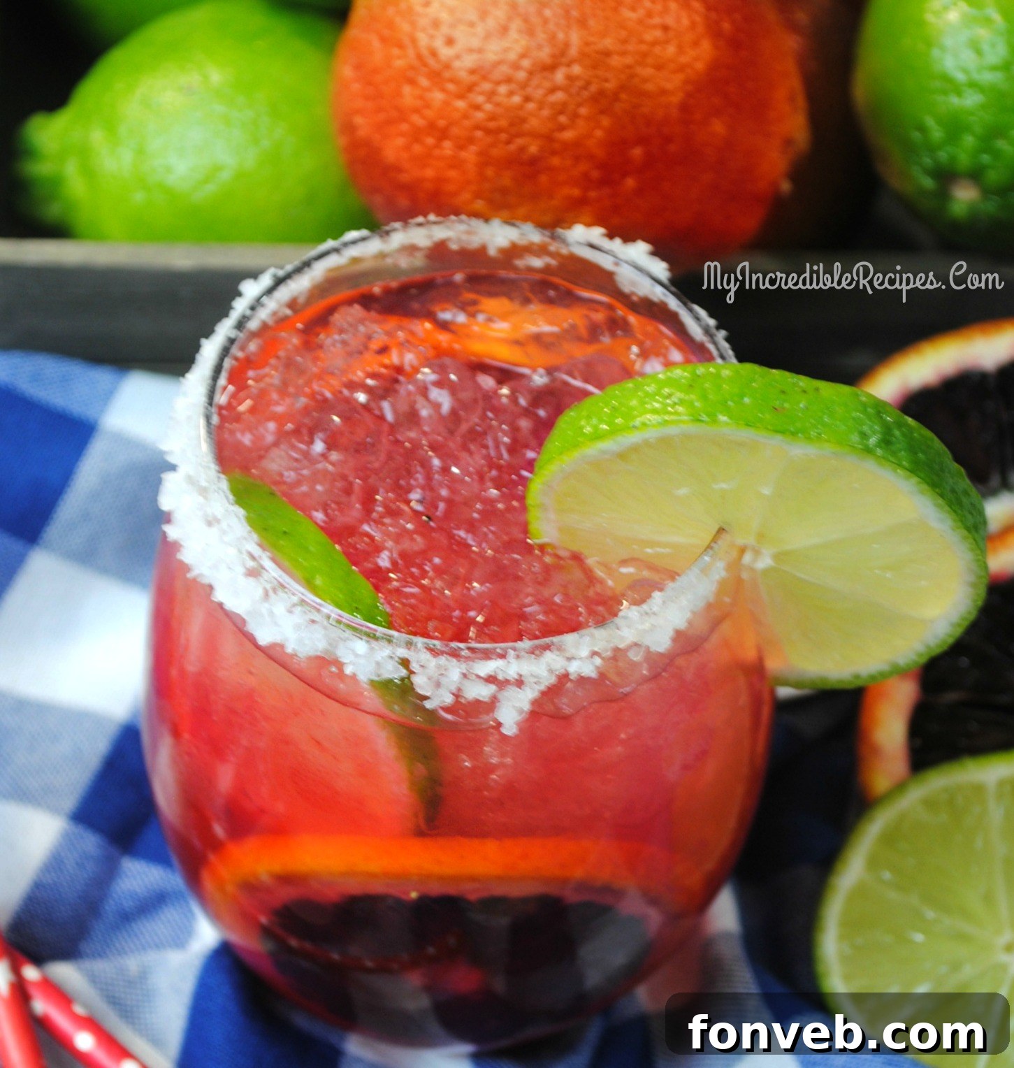 Several Blood Orange Margaritas, each perfectly garnished, arranged on a surface, inviting guests to pick them up and enjoy at a party setting.