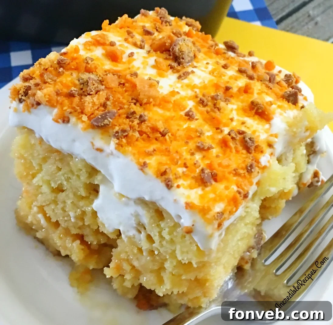 Luscious yellow cake topped with creamy frosting and crushed Butterfinger candy, ready to be served.
