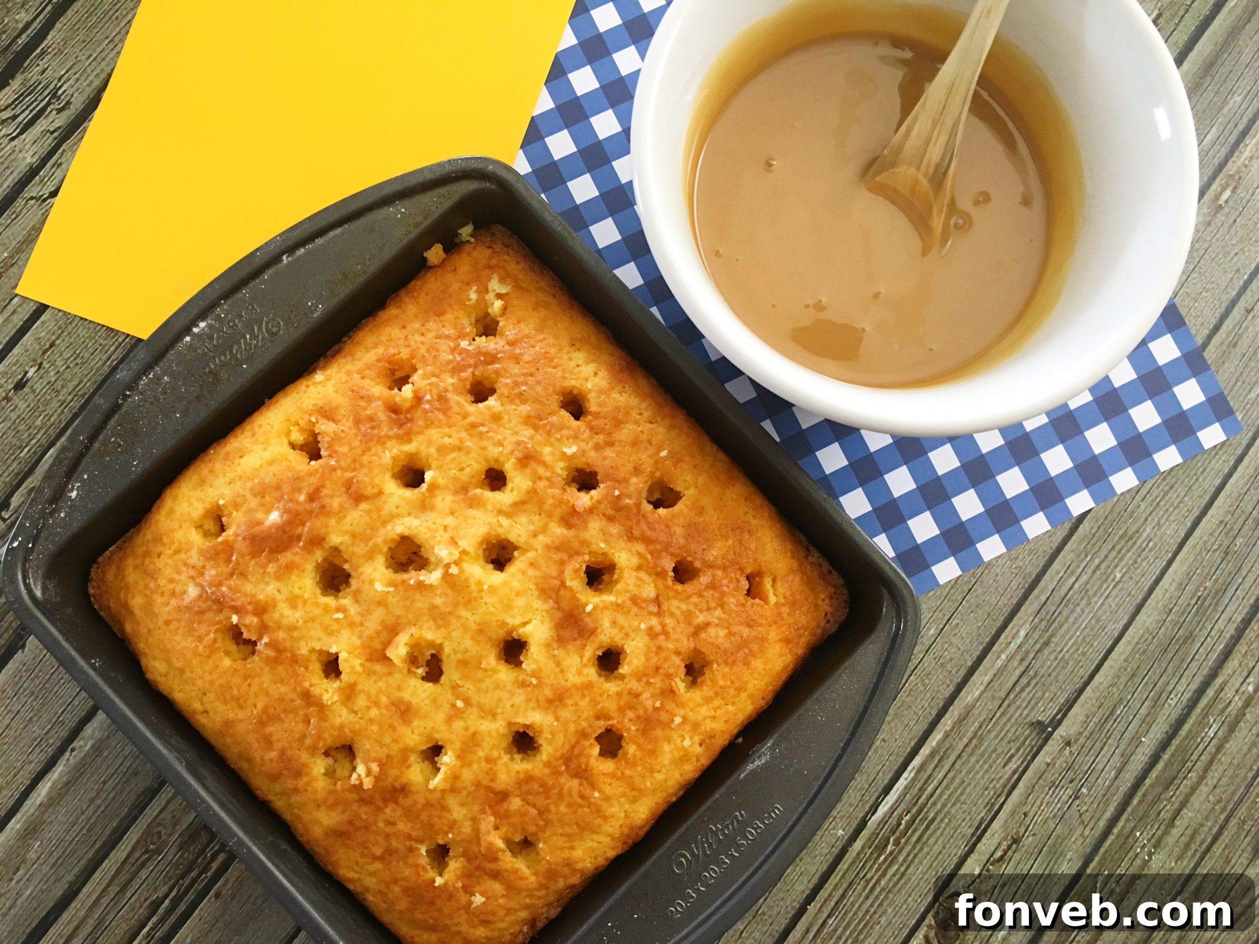 Various simple ingredients laid out on a counter, including a cake mix box, sweetened condensed milk, and caramel syrup.