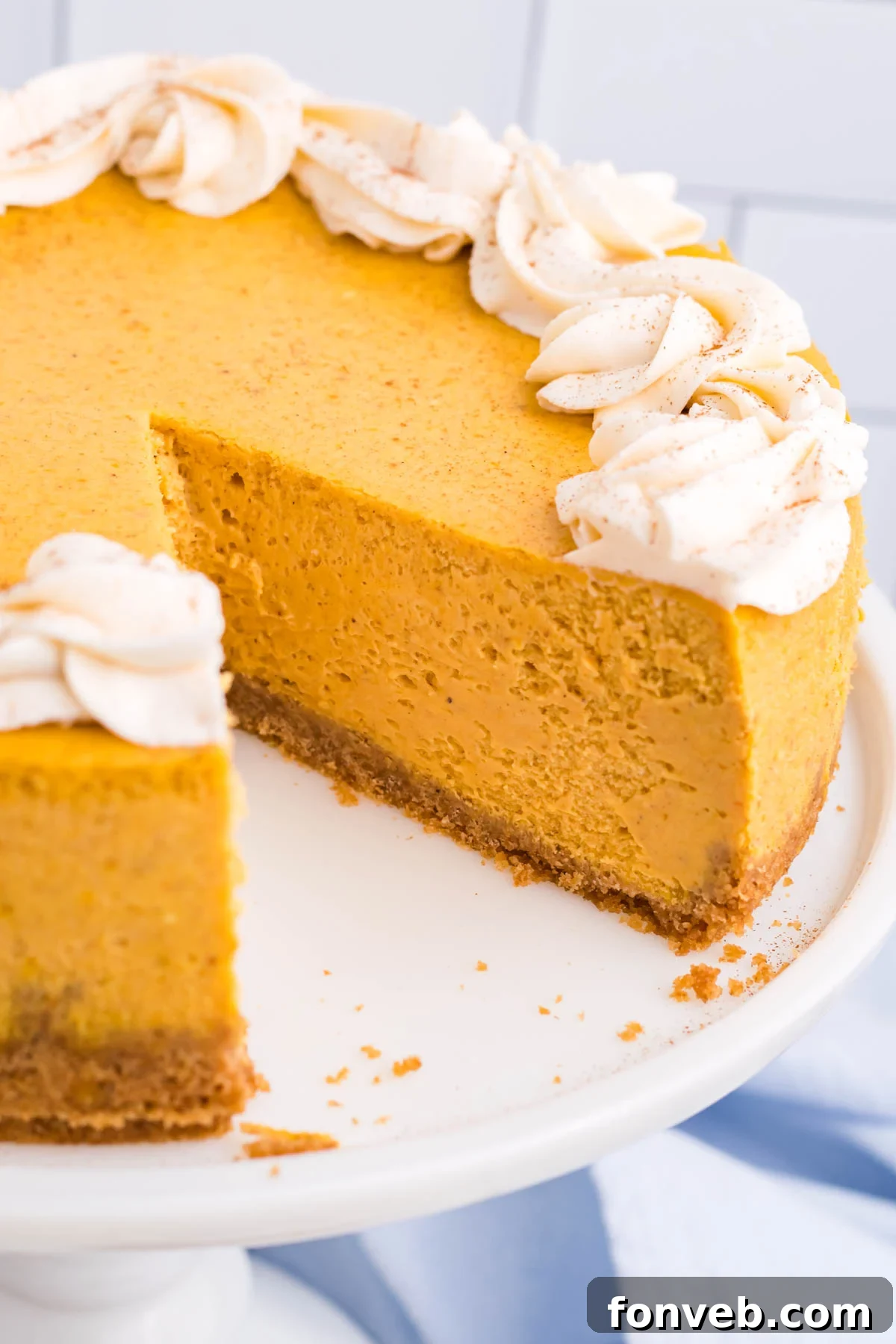 Rich Pumpkin Cheesecake on an elegant white cake stand, ready to be served