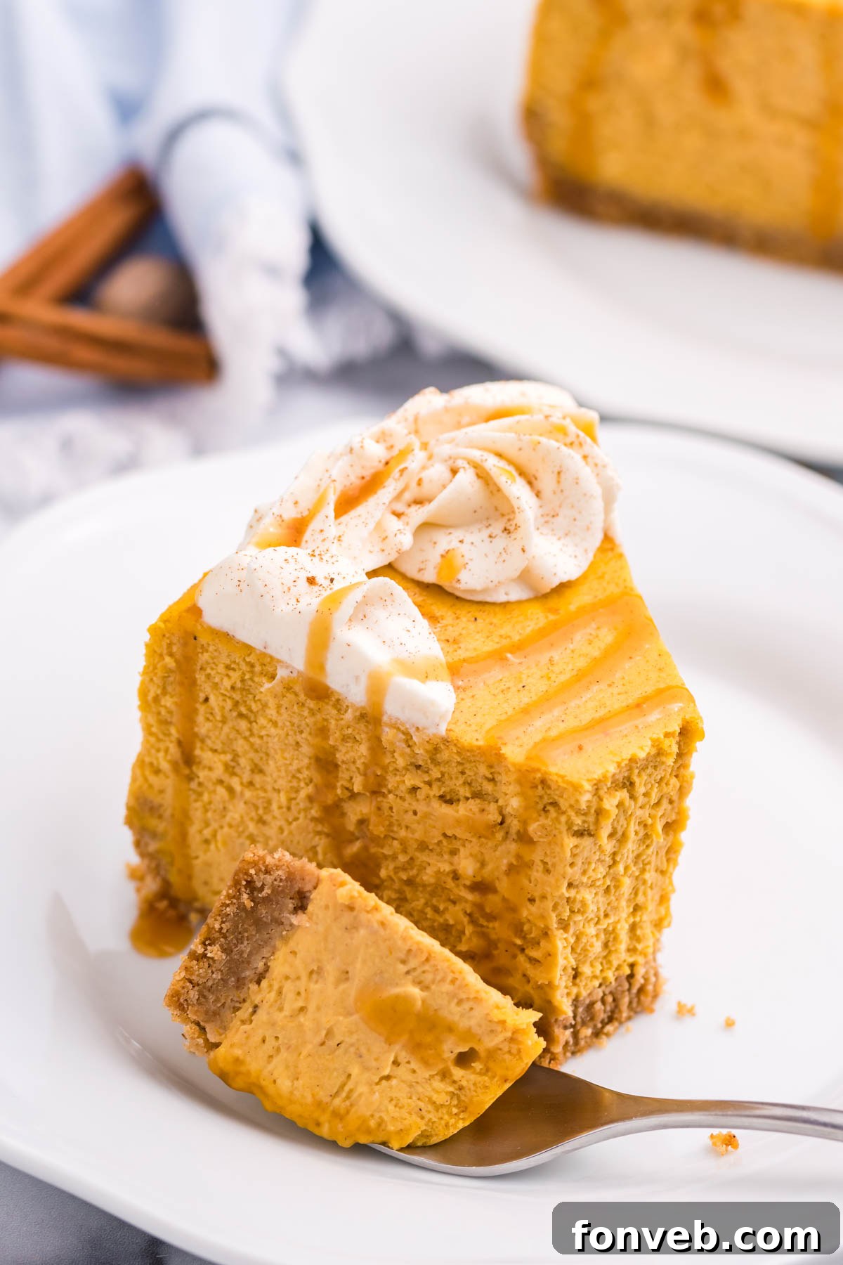 A perfectly portioned slice of Pumpkin Cheesecake on a simple white plate, ready to enjoy
