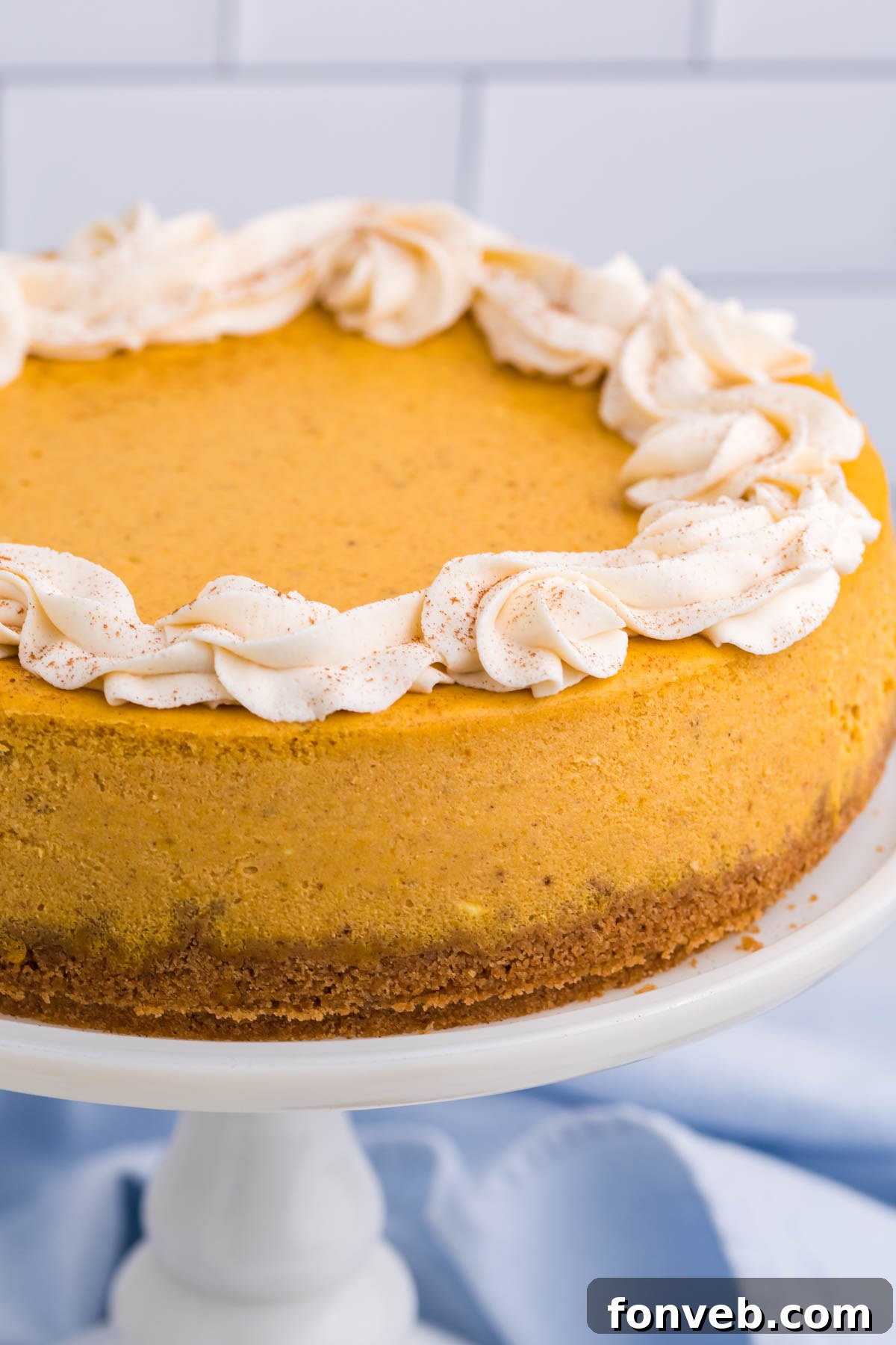 A close-up of the entire uncut Pumpkin Cheesecake, highlighting its smooth, even top