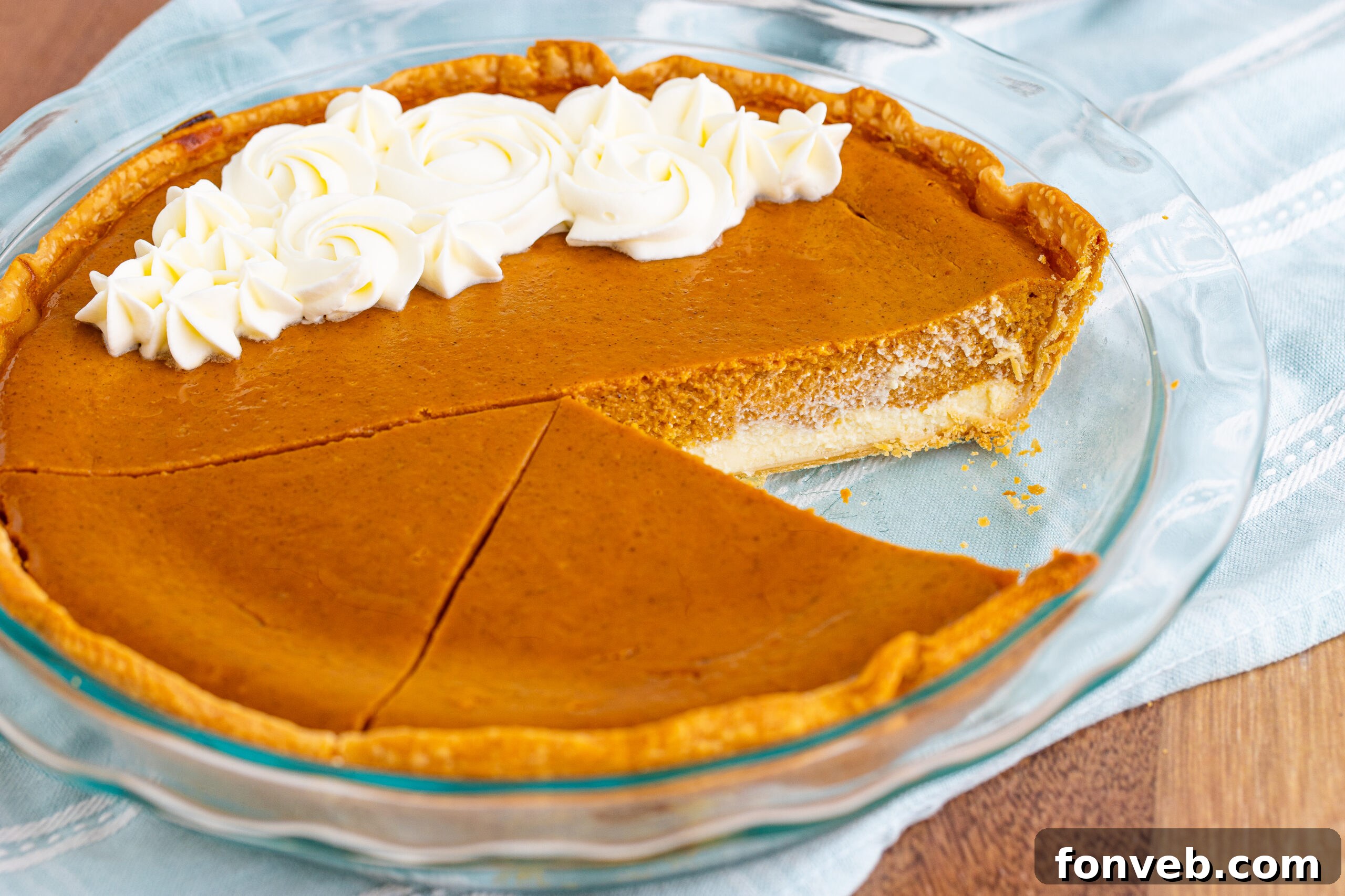 Whole Pumpkin Pie Cheesecake in a clear glass pie dish, ready to be sliced