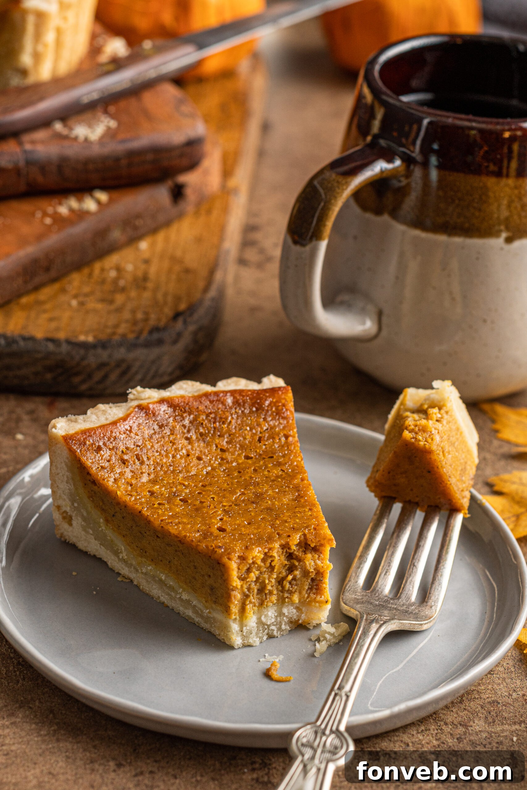 A slice of Pumpkin Pie Tart on a gray plate with a bite missing, ready for another delicious forkful