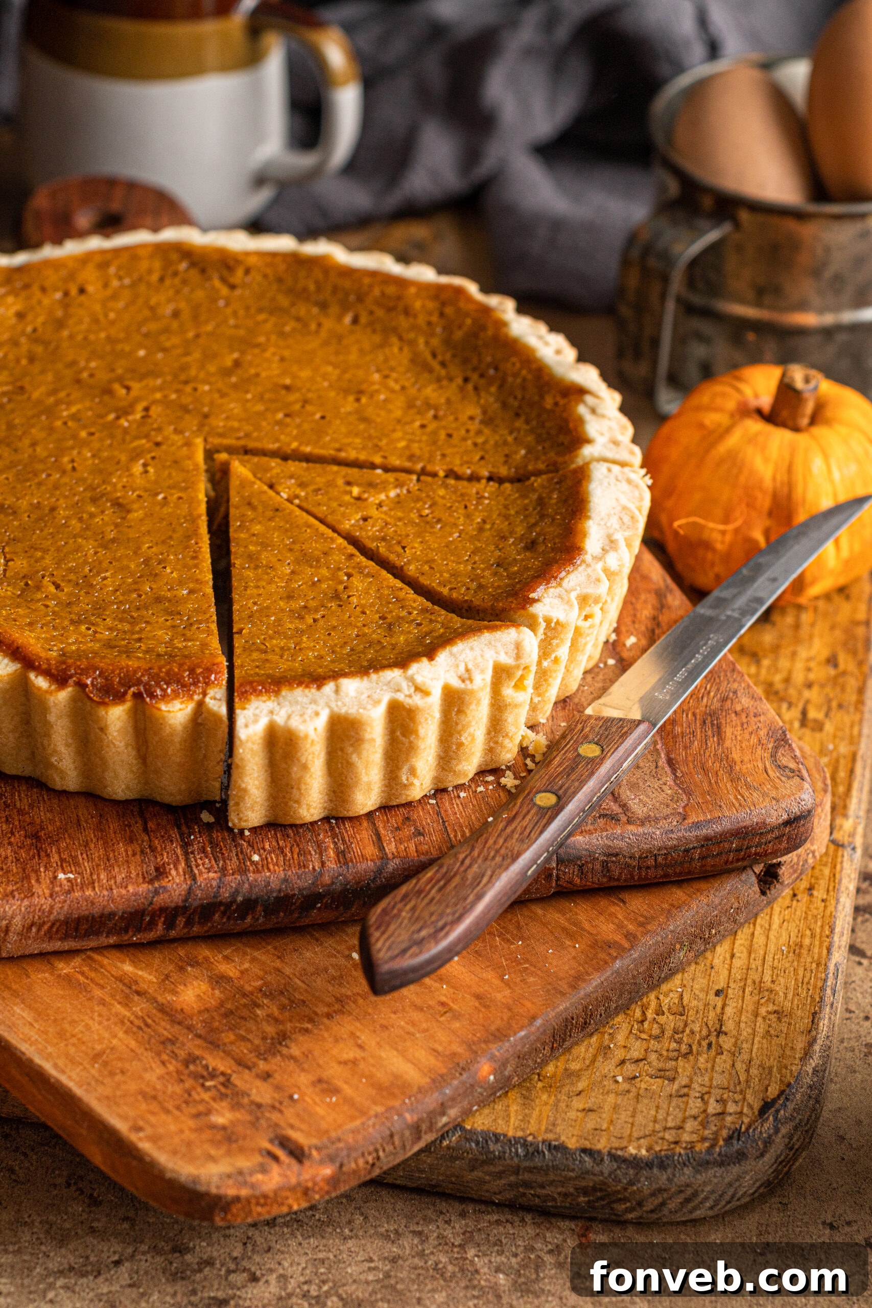 Three Pumpkin Pie Tarts displayed on different wooden cutting boards, ready for serving