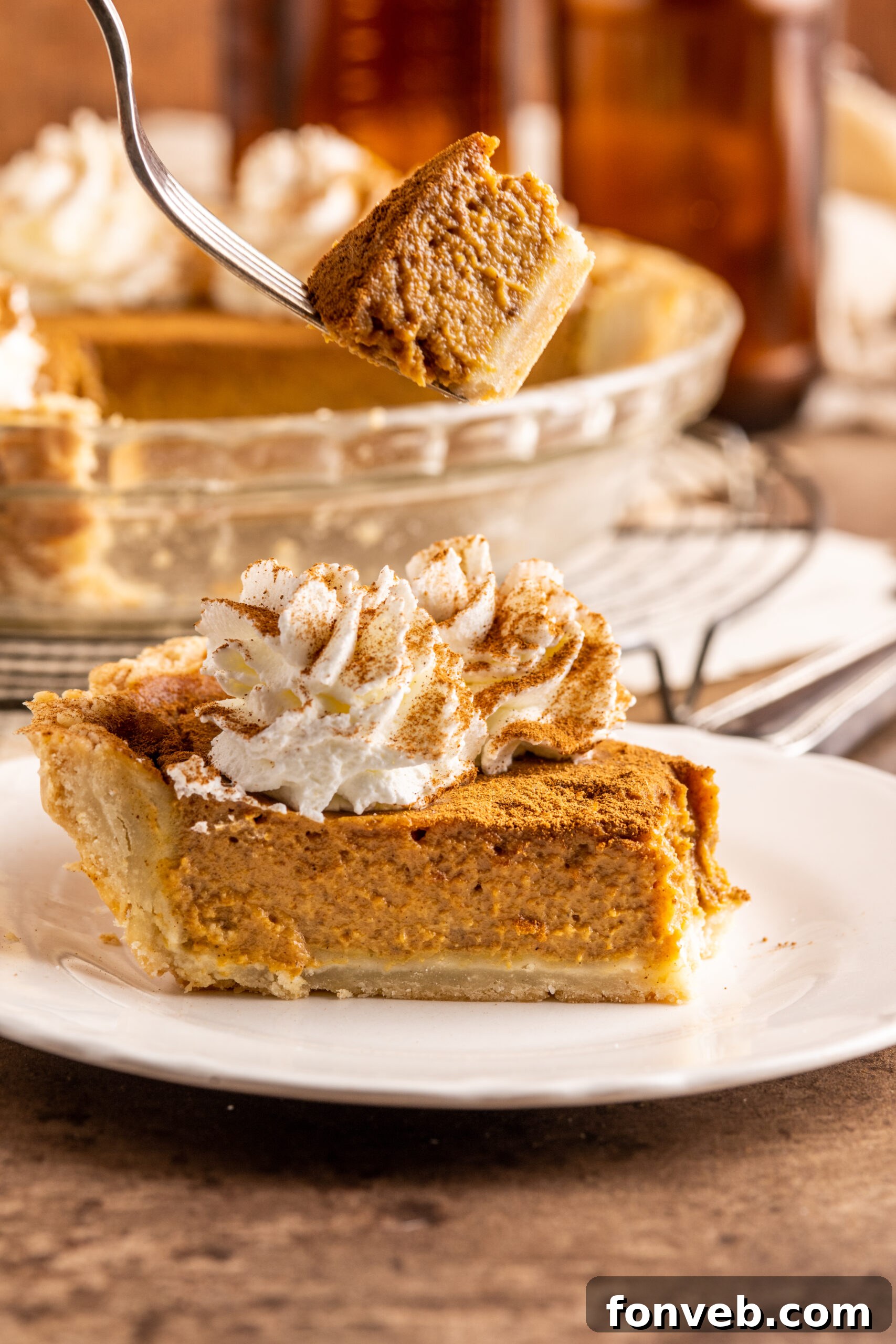 Velvet Pumpkin Dream Pie 10 A close-up of a Pumpkin Custard Pie slice, with a fork lifting a perfect bite, showcasing the creamy filling and flaky crust.