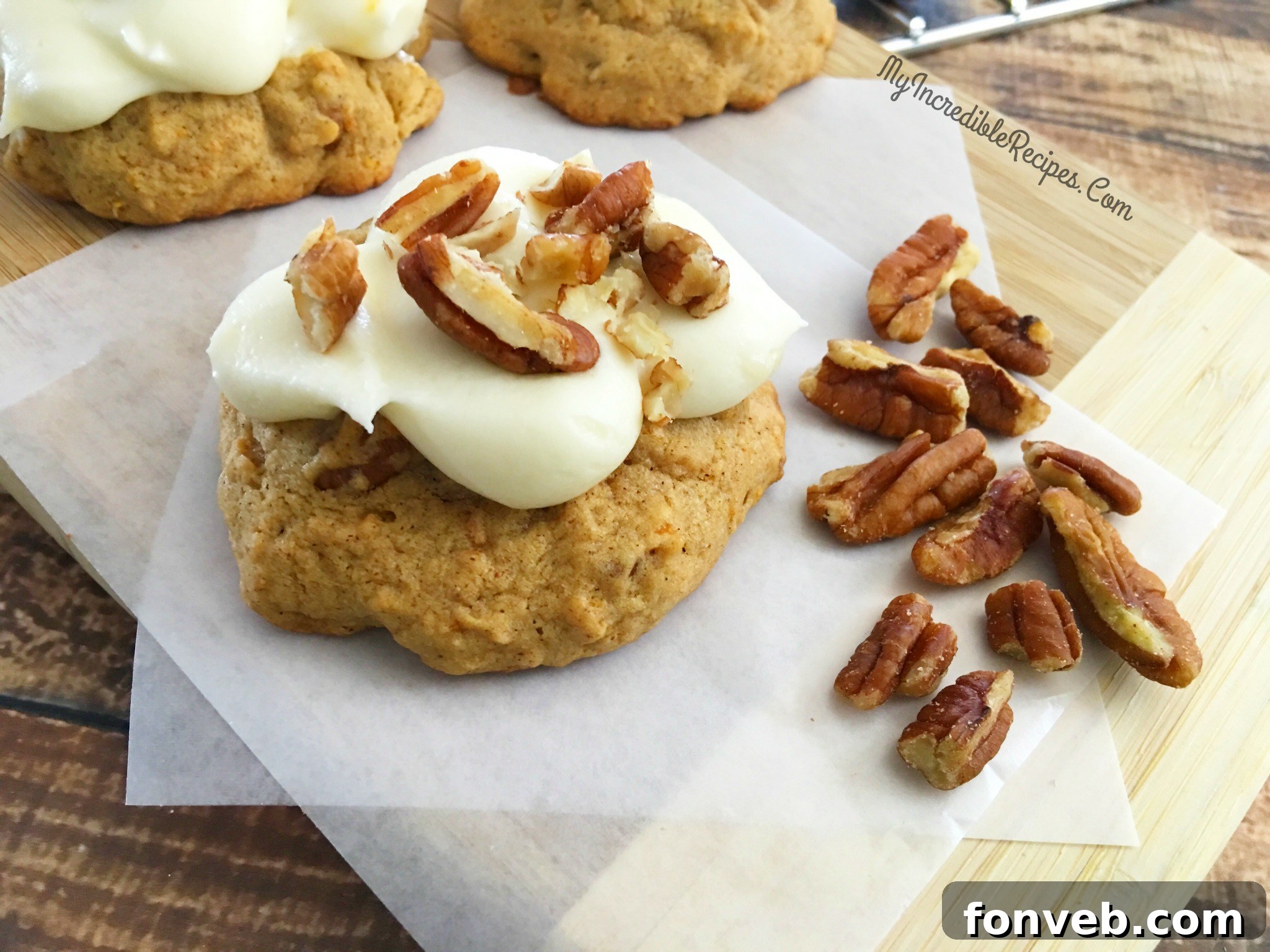 A person taking a bite out of a frosted carrot cake cookie