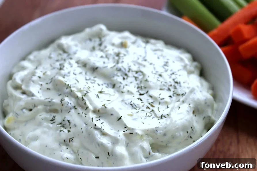 Creamy Dill Pickle Dip served in a white bowl with potato chips, ready for snacking.