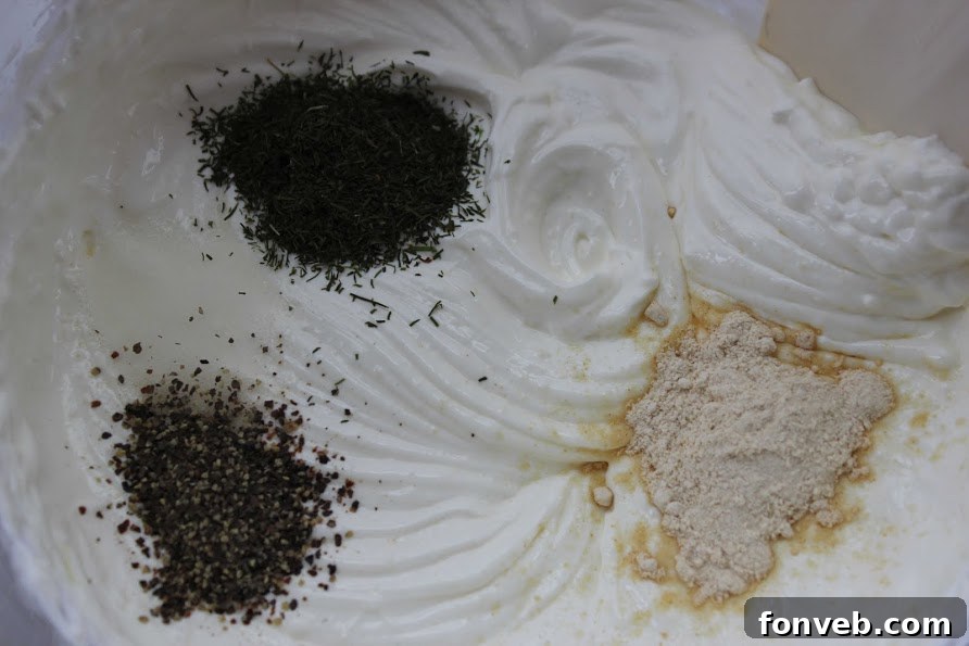 Dill Pickle Dip elegantly displayed on a serving platter with a variety of fresh vegetables and crackers for dipping.