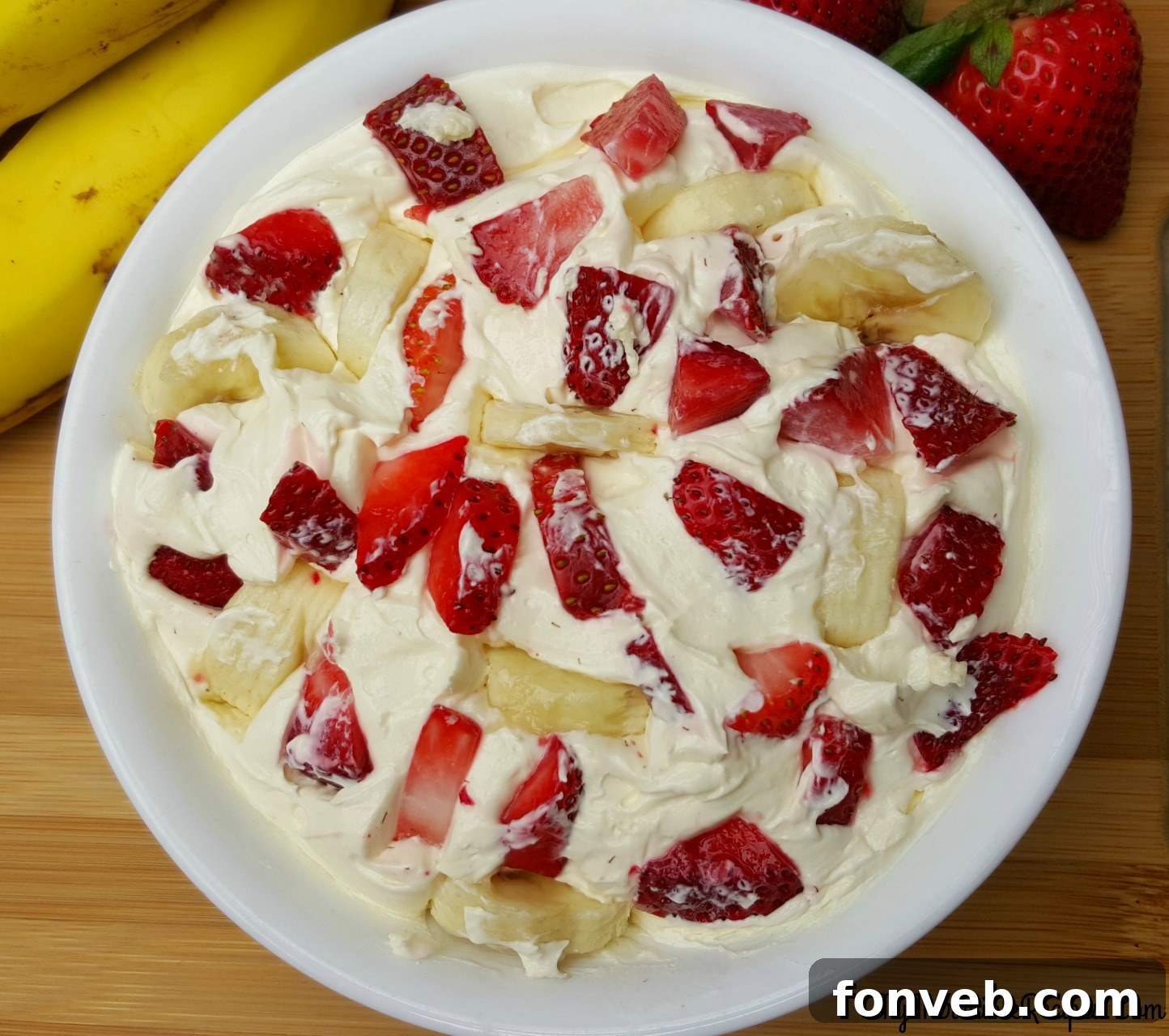 Strawberry Banana Cheesecake Delight 9 A close-up of a serving of Strawberry Banana Cheesecake Salad, highlighting the layers of creamy filling and fresh fruit.
