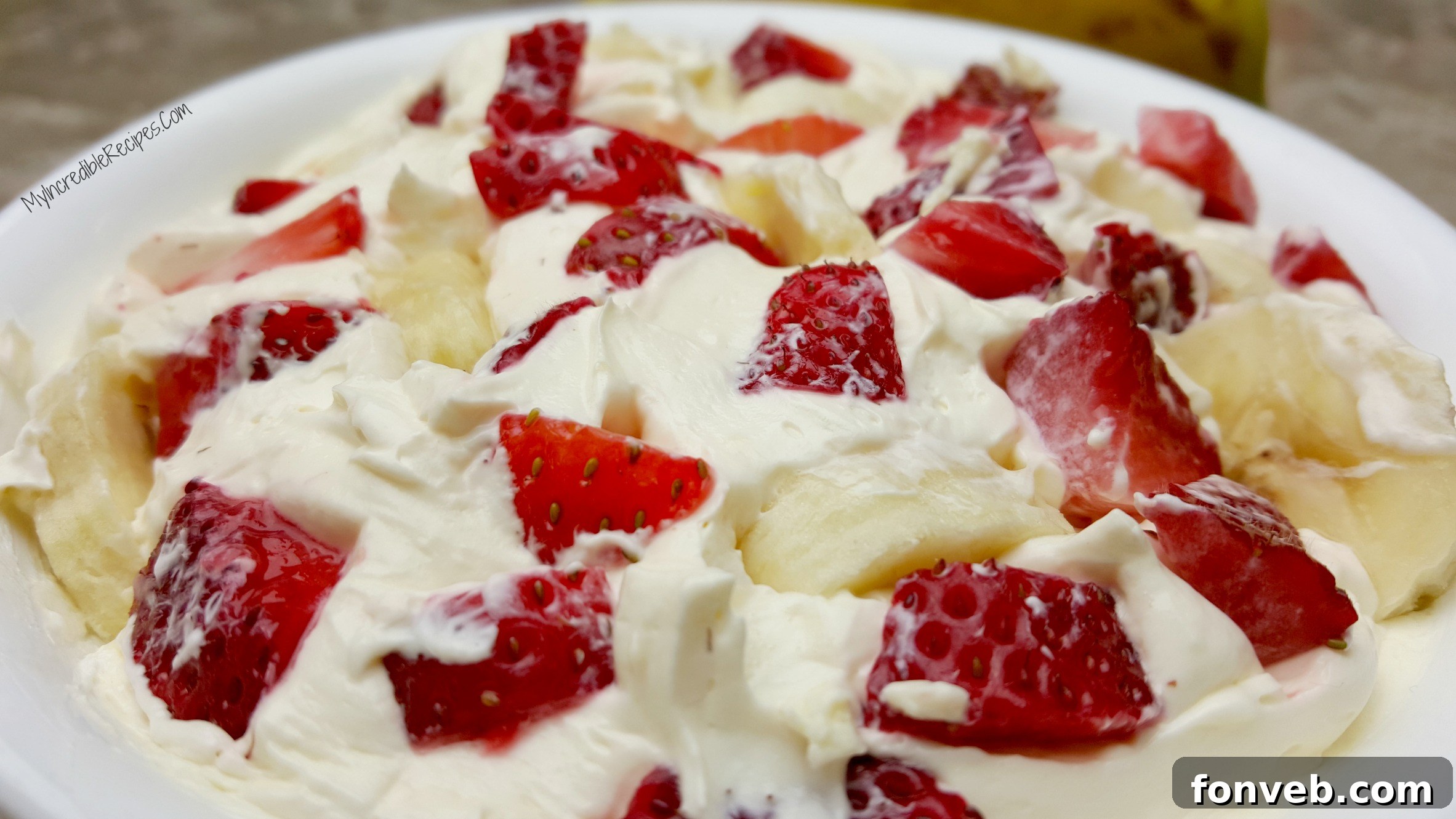 Strawberry Banana Cheesecake Delight 10 A large bowl of Strawberry Banana Cheesecake Salad, garnished with extra fruit, ready for a party.