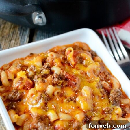A top-down view of Old Fashioned Goulash in a rustic pot, garnished with fresh herbs.