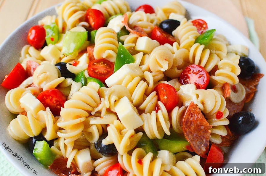 Delicious Italian Pizza Pasta Salad with pepperoni and colorful vegetables in a large serving bowl
