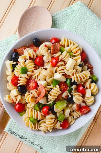 A vibrant bowl of Italian Pizza Pasta Salad, showing a fresh mix of pasta, pepperoni, and colorful vegetables, ready to be chilled