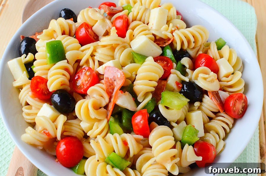 Italian Pizza Pasta Salad presented in a clear glass bowl, showcasing its appeal for a gathering