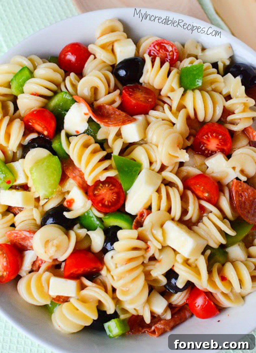 Close-up of the fully mixed Italian Pizza Pasta Salad, showcasing the rich textures and colors before serving, emphasizing its appetizing look