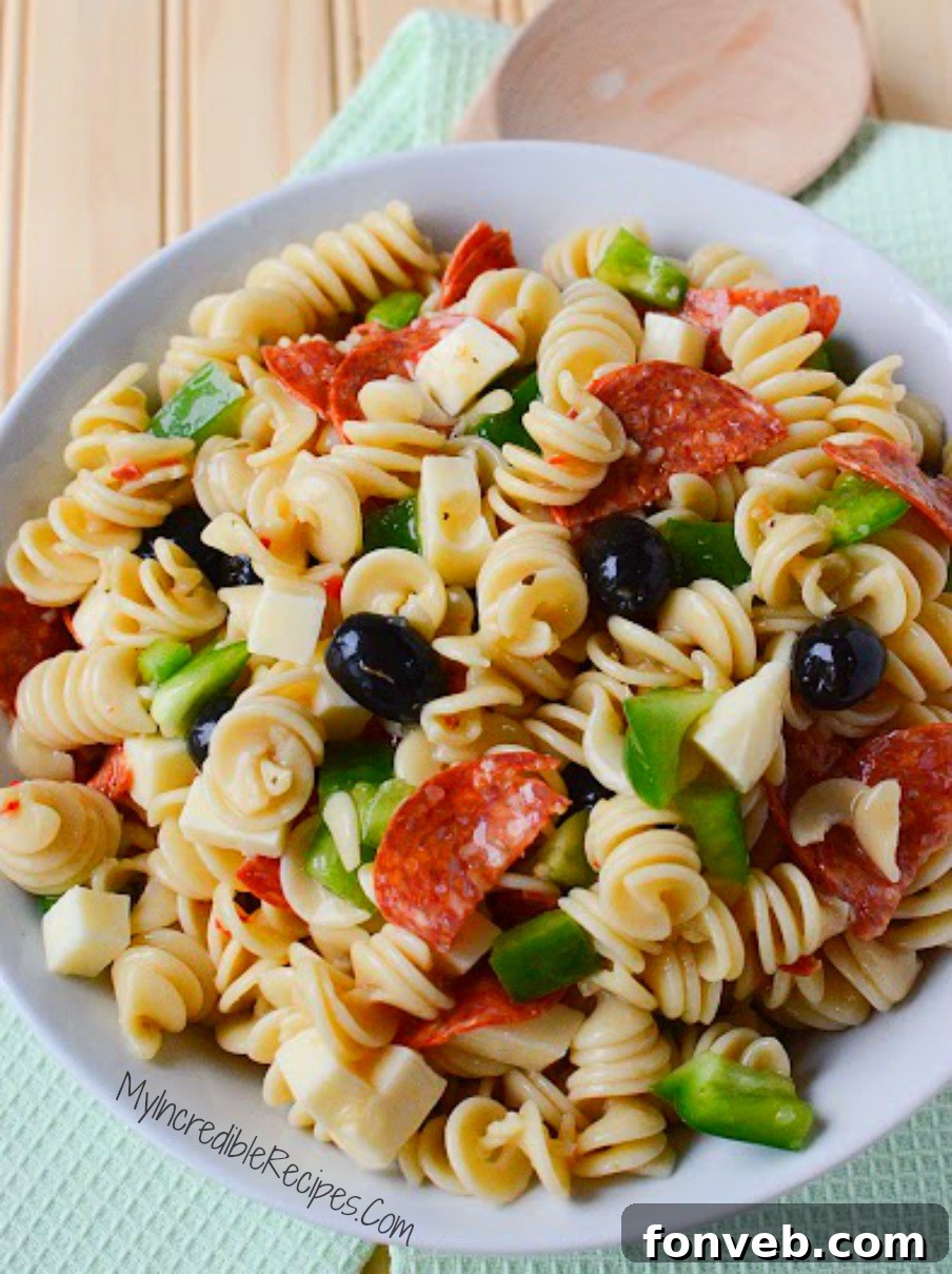 A generous serving of Italian Pizza Pasta Salad with extra pepperoni on top, illustrating a customization option for meat lovers
