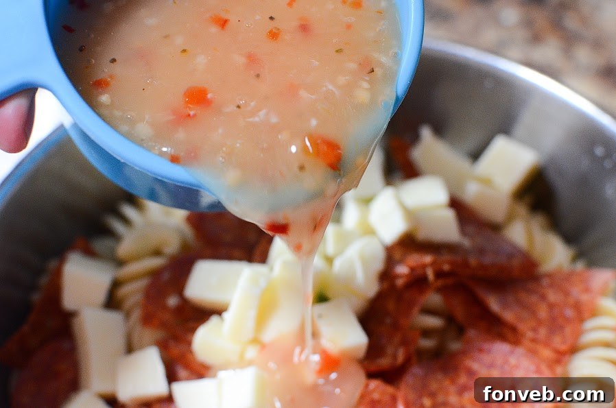 A large serving bowl filled with Italian Pizza Pasta Salad, highlighting the fresh, crisp ingredients and rotini pasta