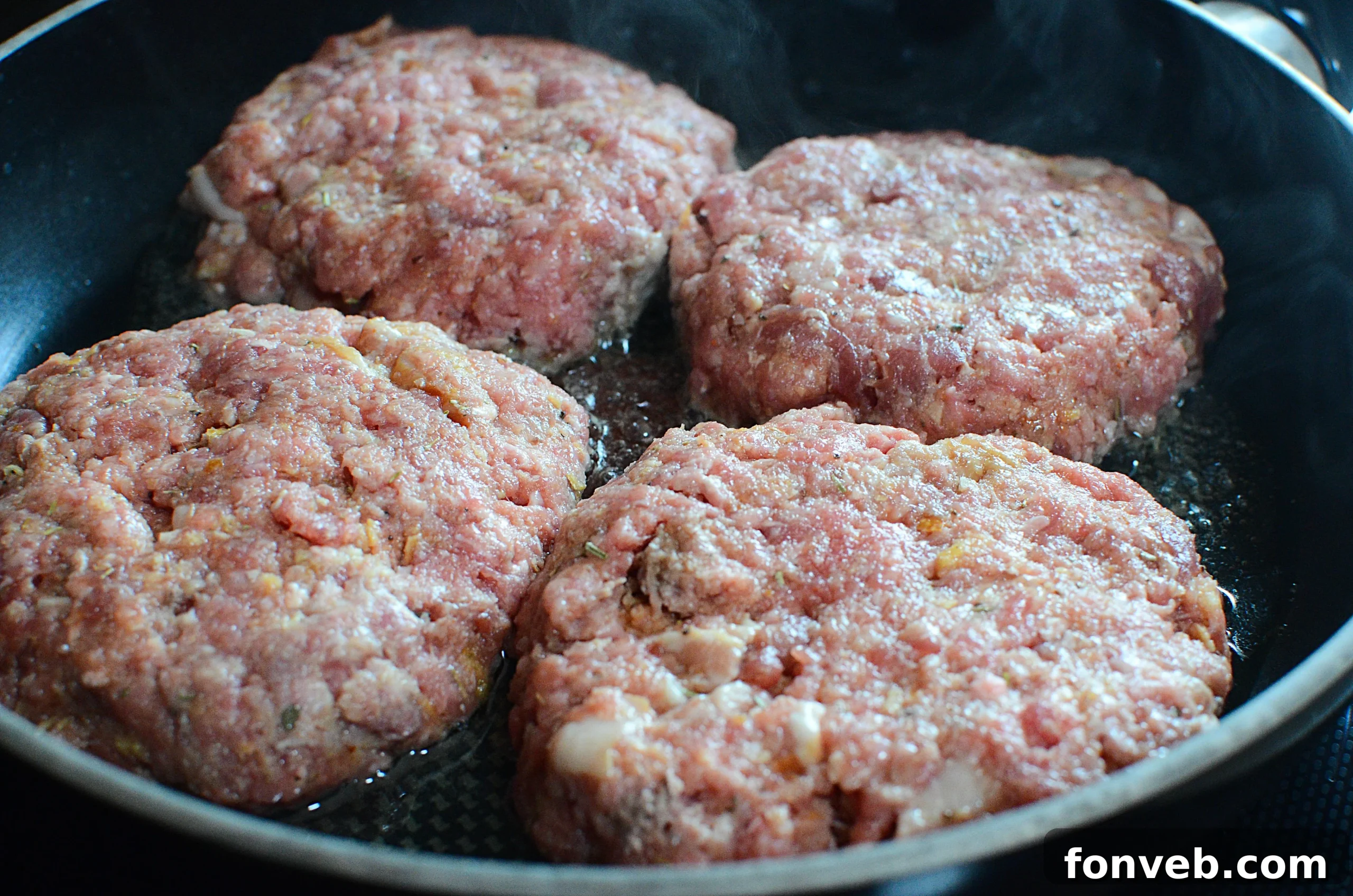 Mixed hamburger steak ingredients in a pan with chopped onions and mushrooms.