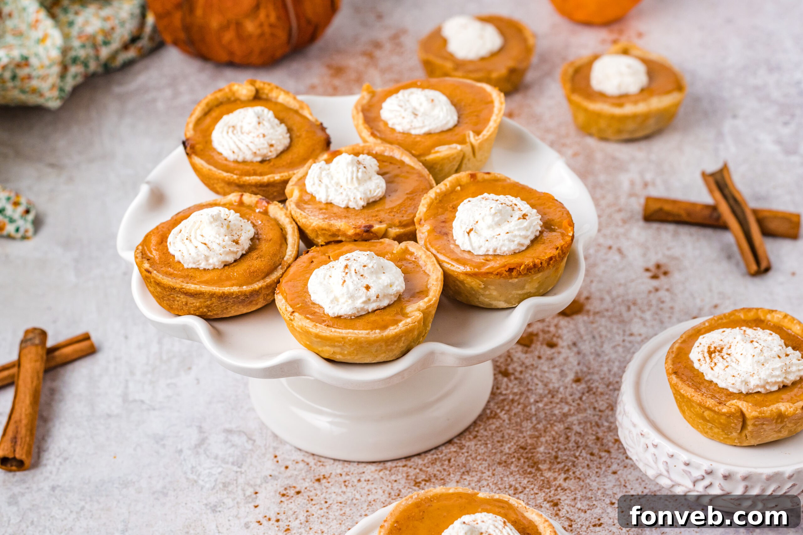 Mini Pumpkin Pies arranged neatly on a white serving tray, ready to be enjoyed