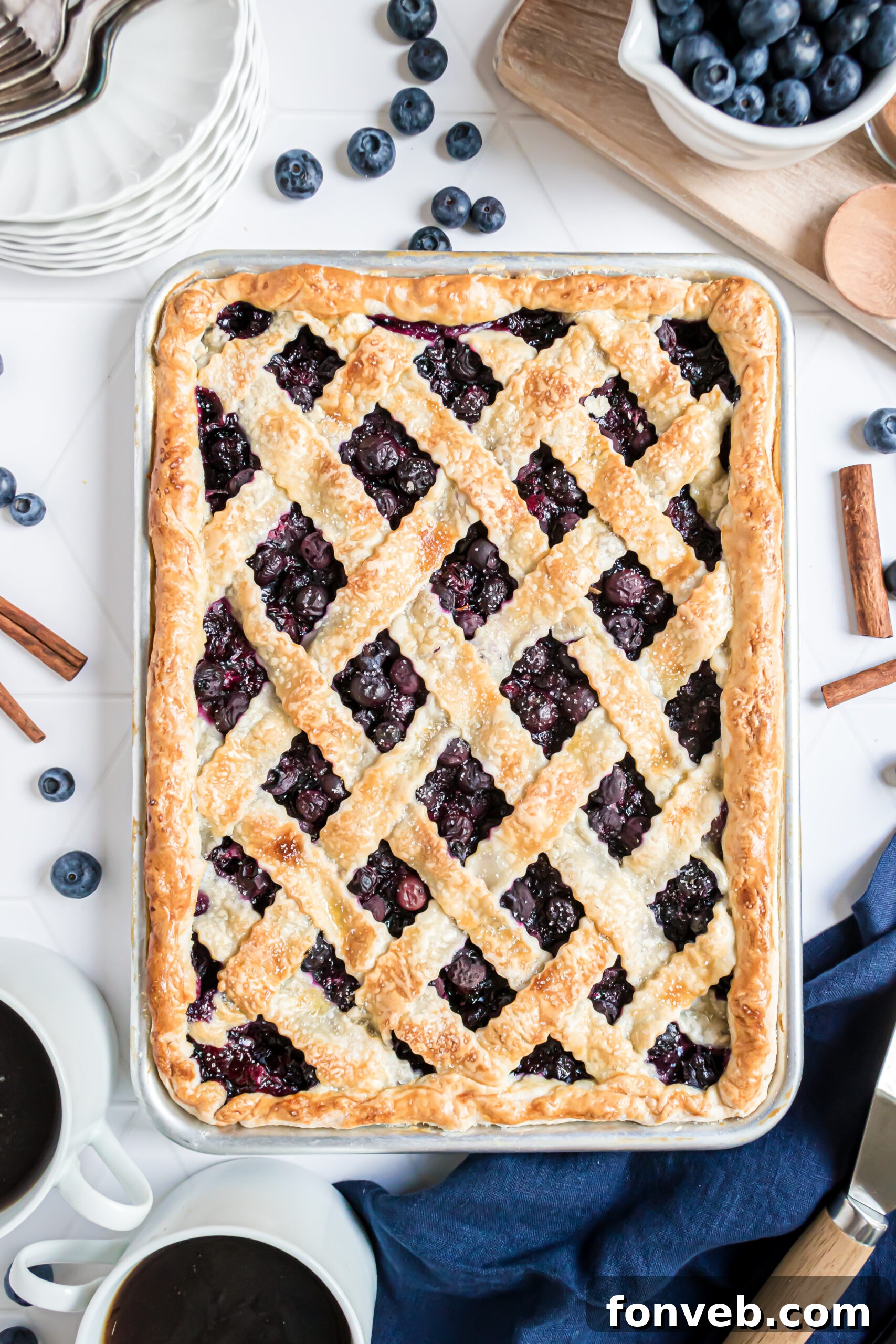 An inviting overhead view of the complete blueberry slab pie, baked to golden perfection in a silver baking dish.