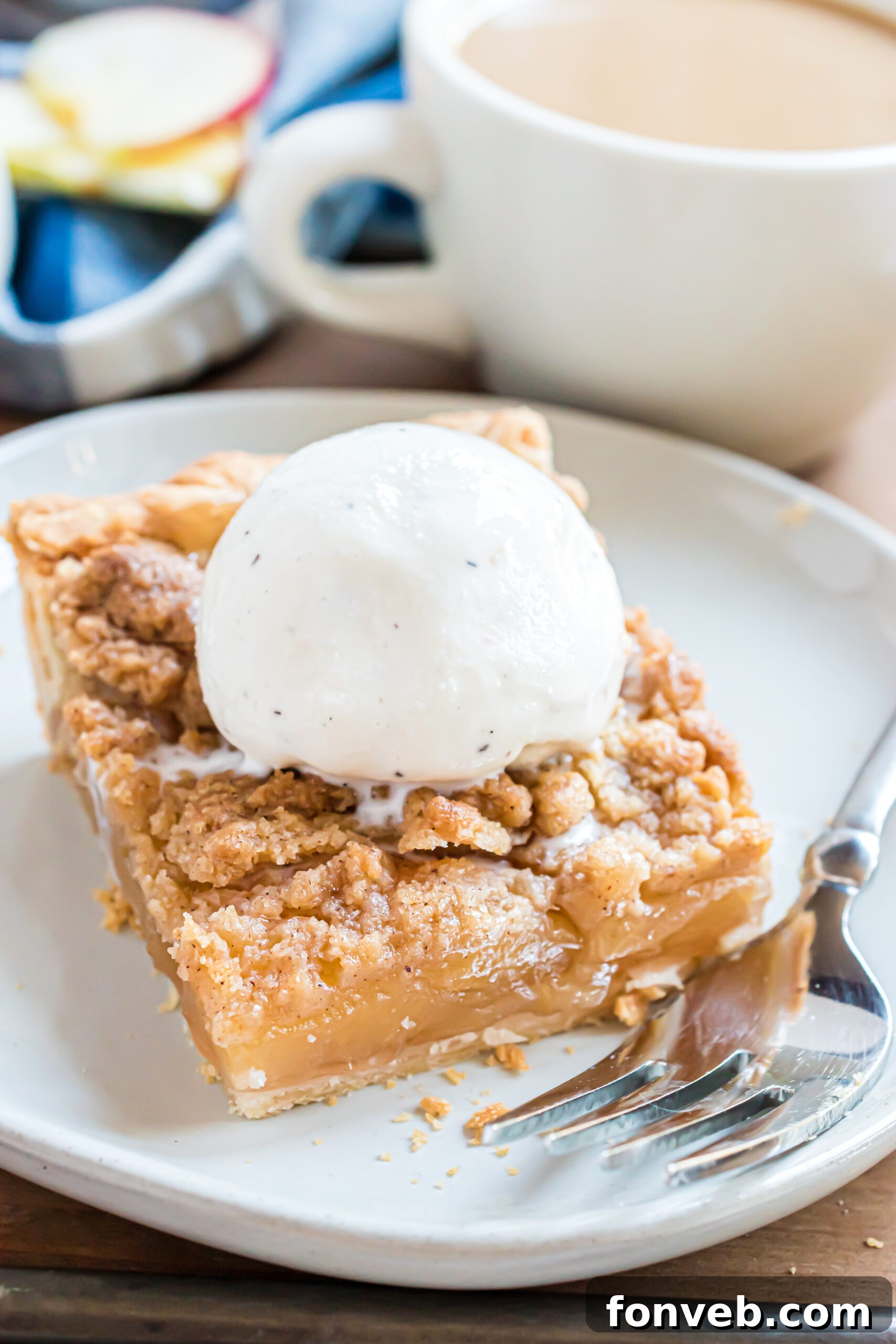 Up close shot of the apple slab pie on a white plate topped with vanilla ice cream 