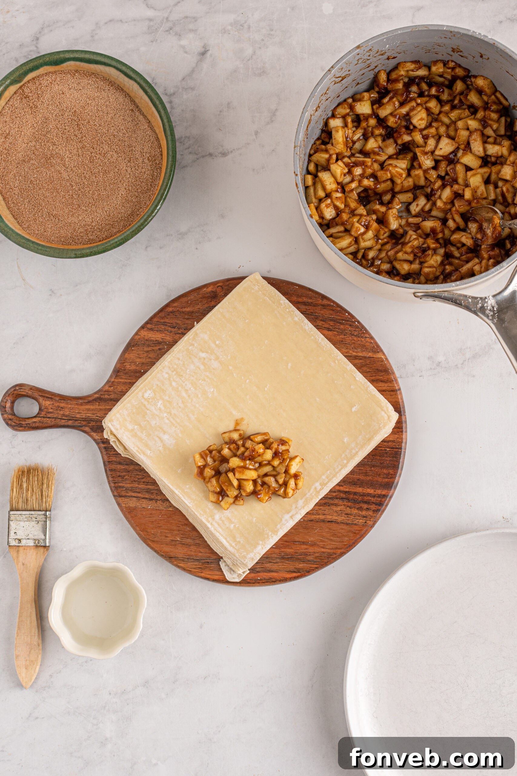 Overhead view of wrapping apple pie egg rolls.