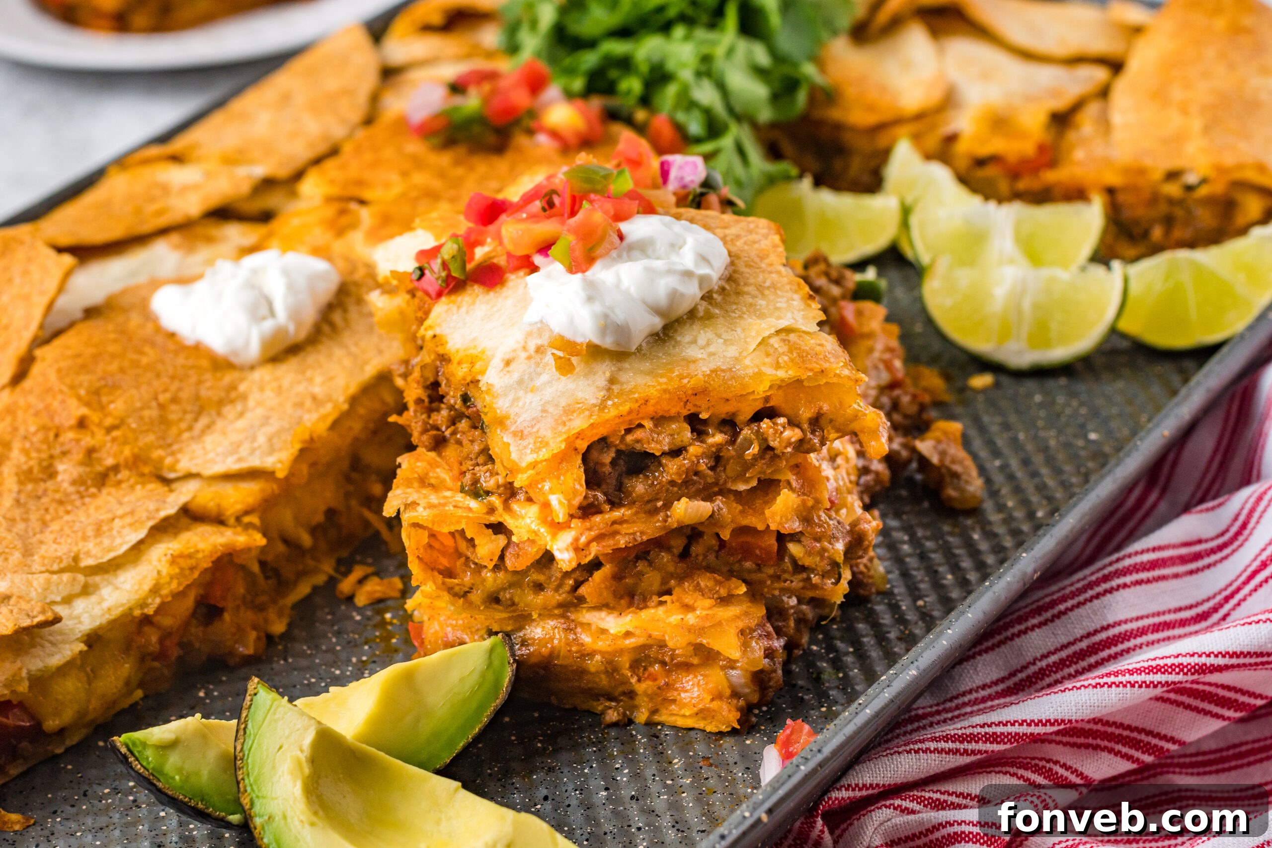 One Pan Baked Tacos 6 Three golden-baked sheet pan tacos, exquisitely stacked on the baking sheet, adorned with swirls of sour cream and a colorful topping of fresh Pico de Gallo
