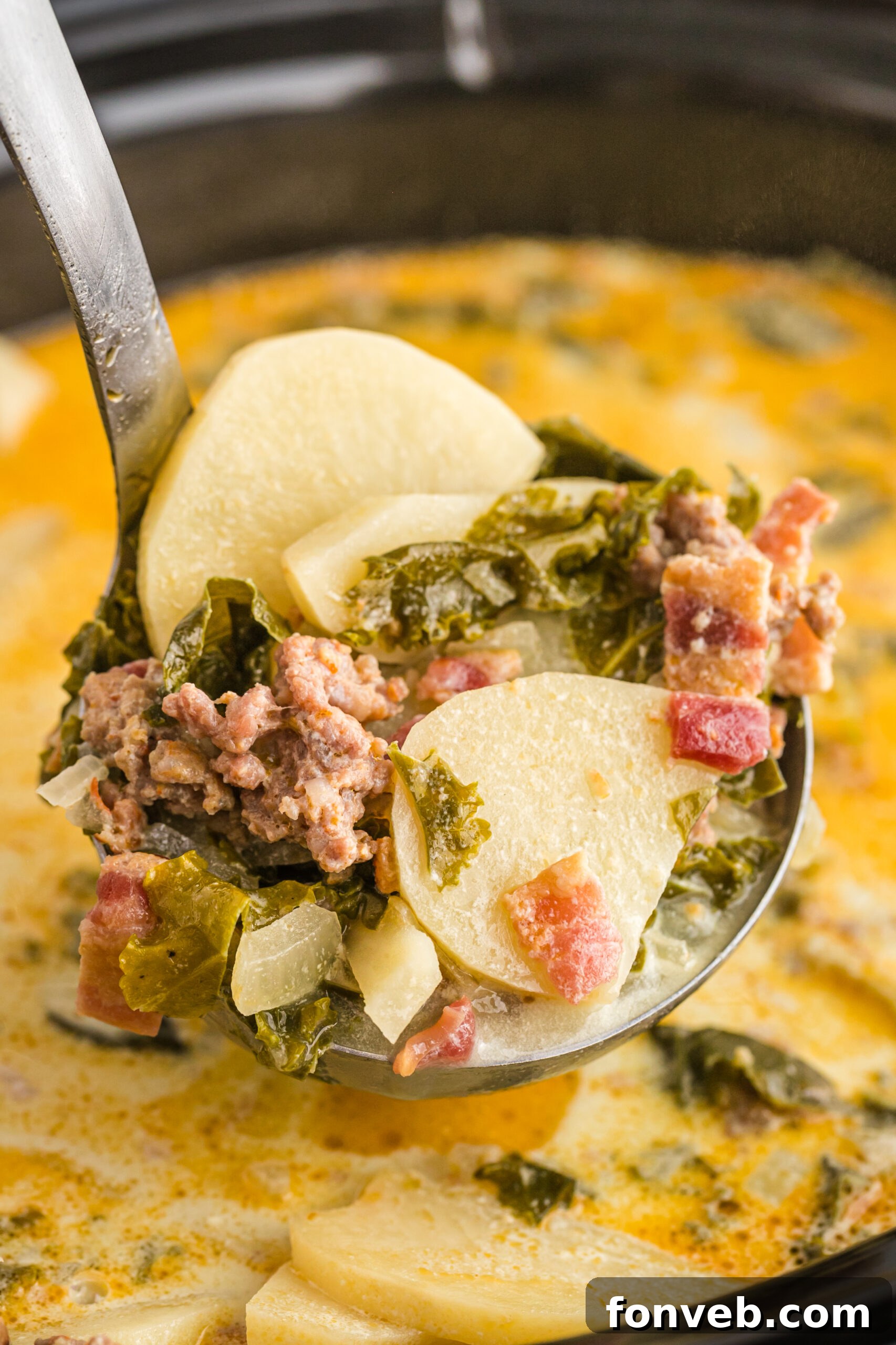 A silver ladle removing Zuppa Toscana Soup from the slow cooker.