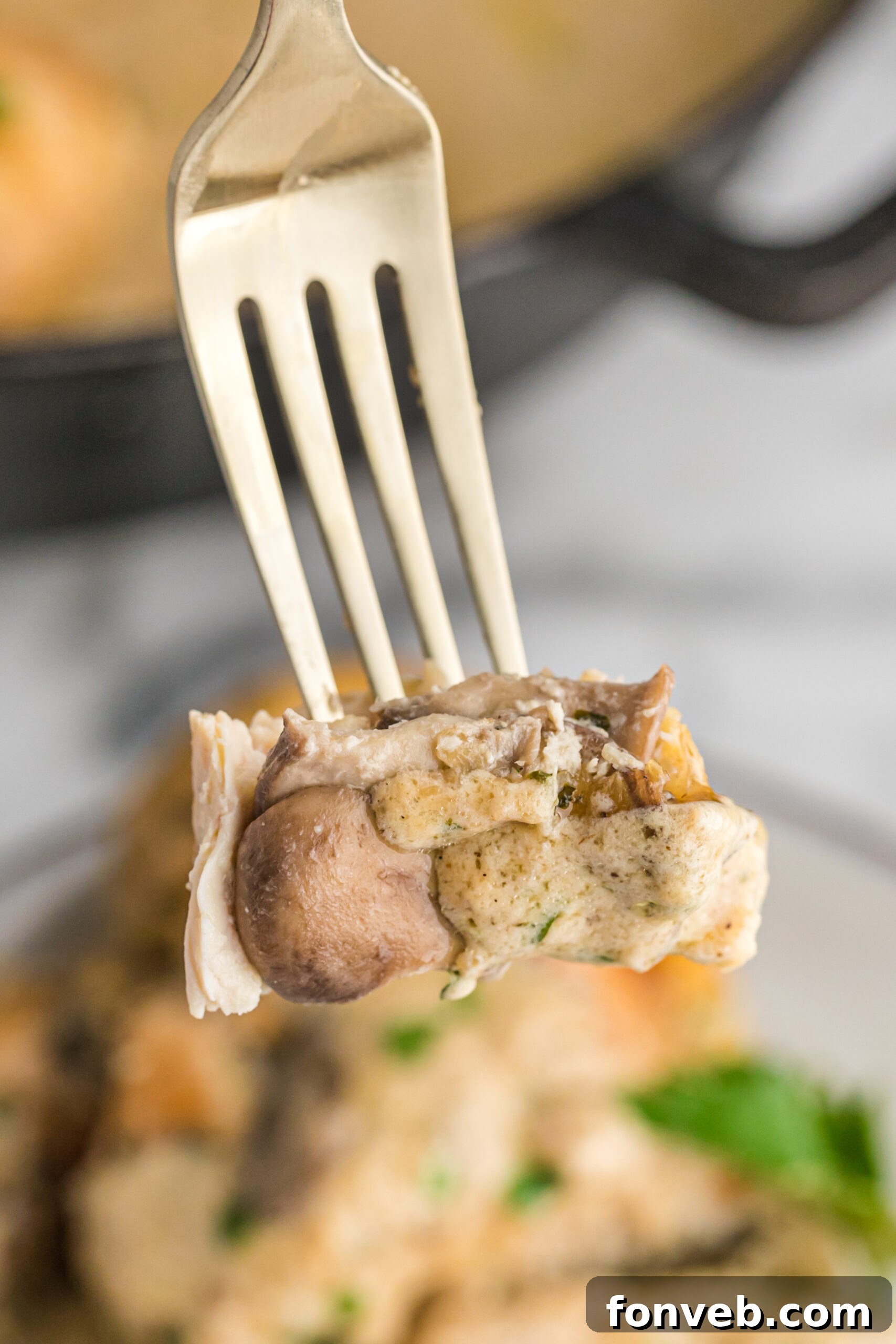 Garlic Butter Chicken Stuffed with Cheesy Mushrooms 13 A close-up shot of a perfectly cooked piece of Cheesy Garlic Butter Mushroom Stuffed Chicken with creamy sauce and herbs, ready to be eaten.