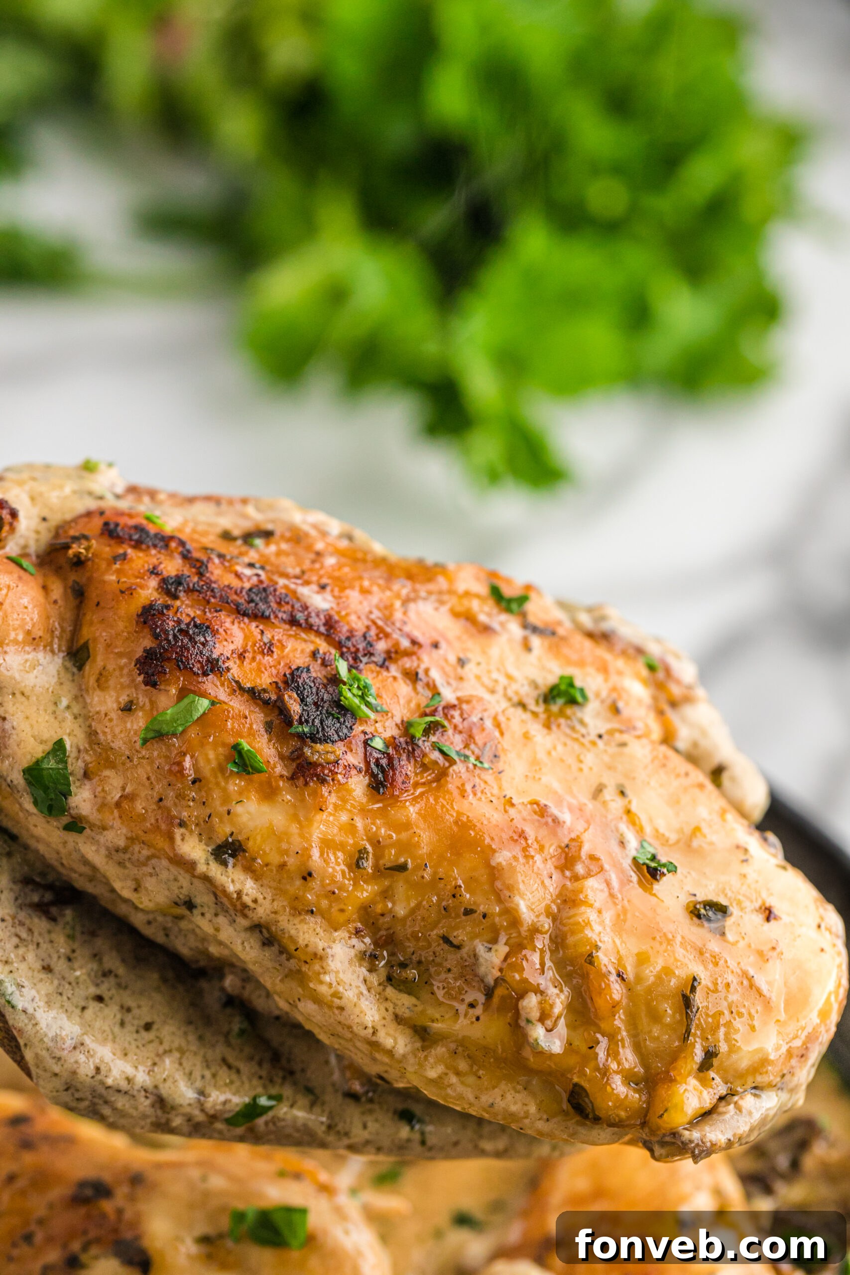 Garlic Butter Chicken Stuffed with Cheesy Mushrooms 3 A piece of golden-brown Cheesy Garlic Butter Mushroom Stuffed Chicken being carefully removed from a cast iron skillet using a wooden spatula, showing its cheesy, mushroom filling.