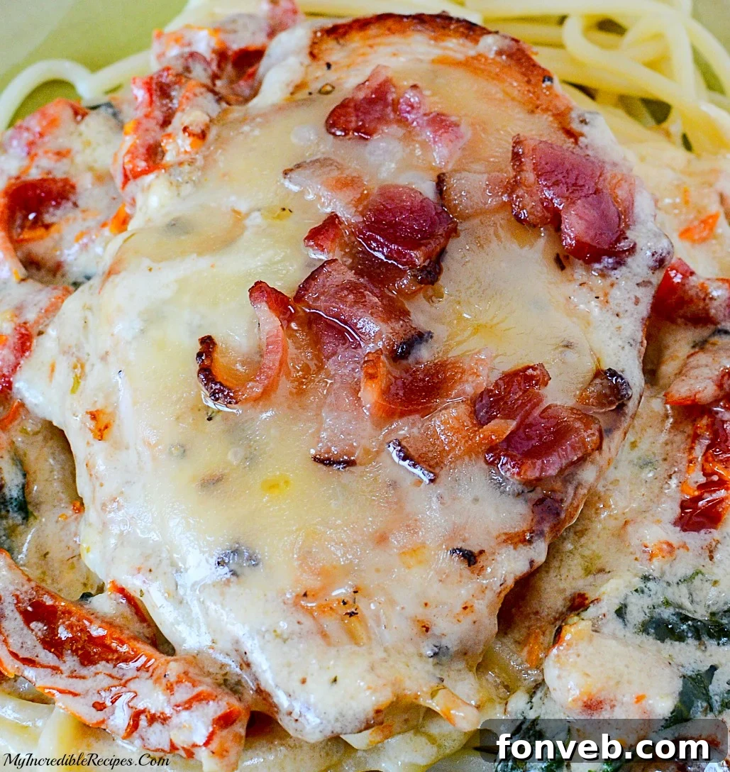 Creamy Garlic Bacon Mozzarella Chicken with Sun-Dried Tomatoes and Spinach served over pasta