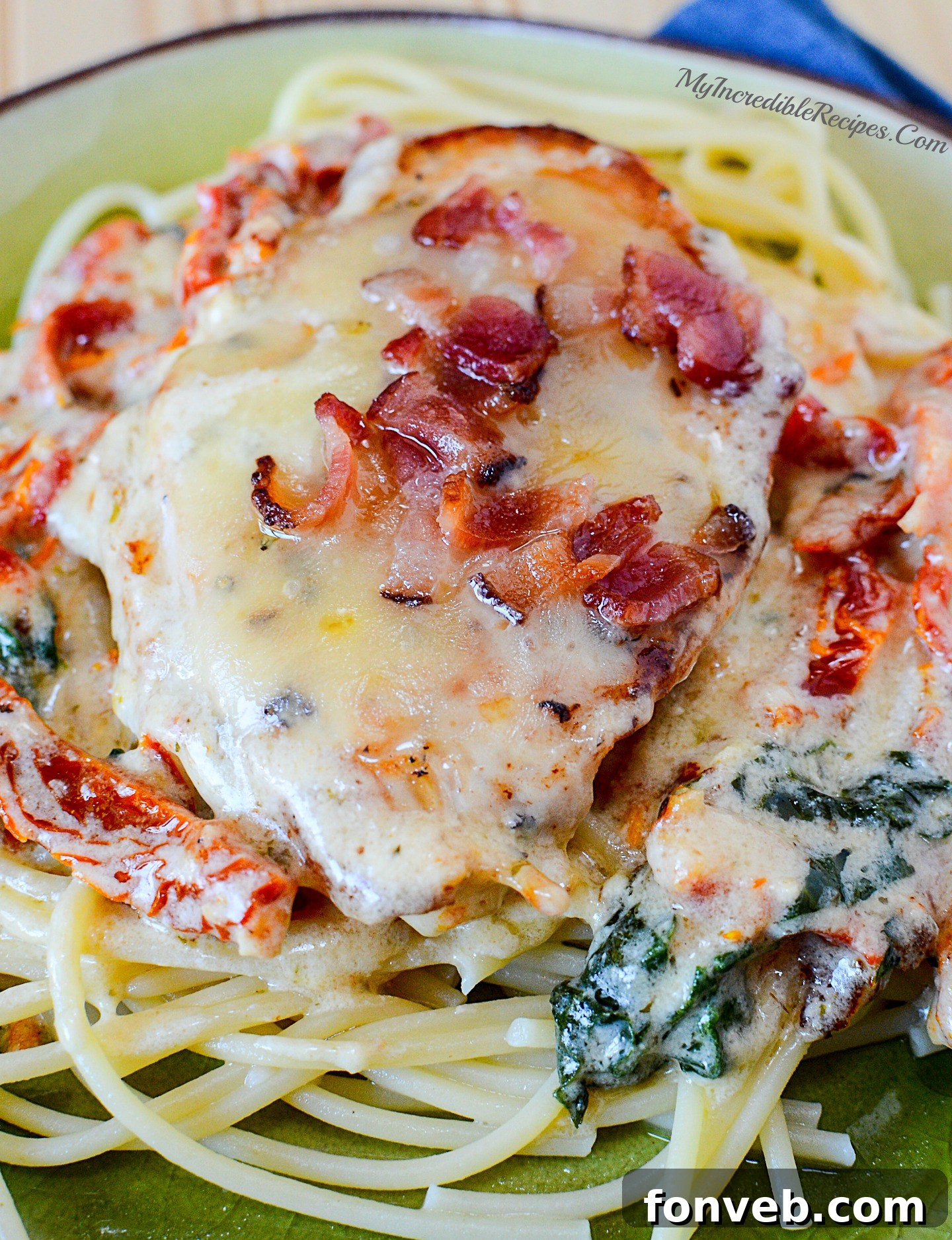 Close-up of melted mozzarella cheese and crispy bacon on creamy garlic chicken