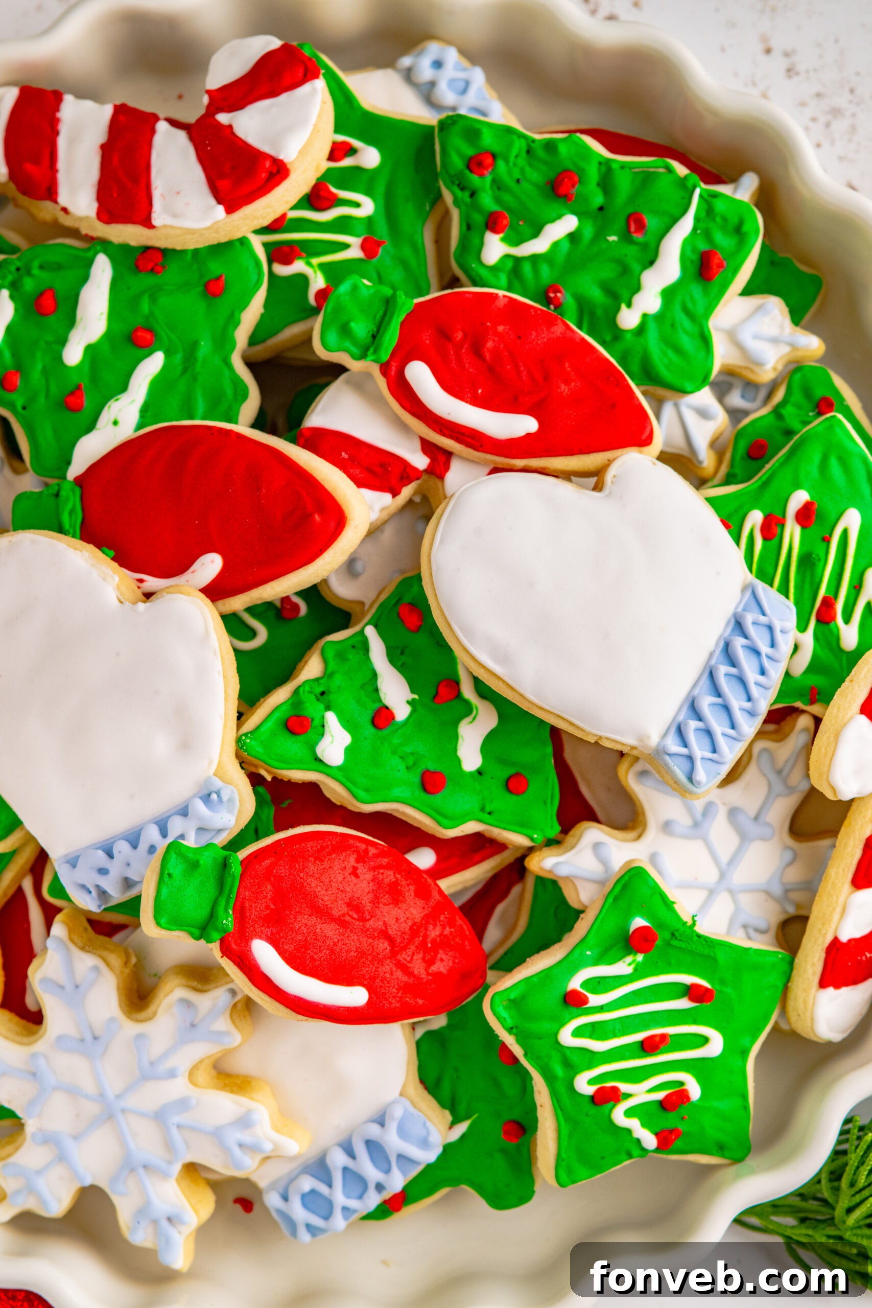 Christmas Sugar Cookies stacked on a white serving tray.