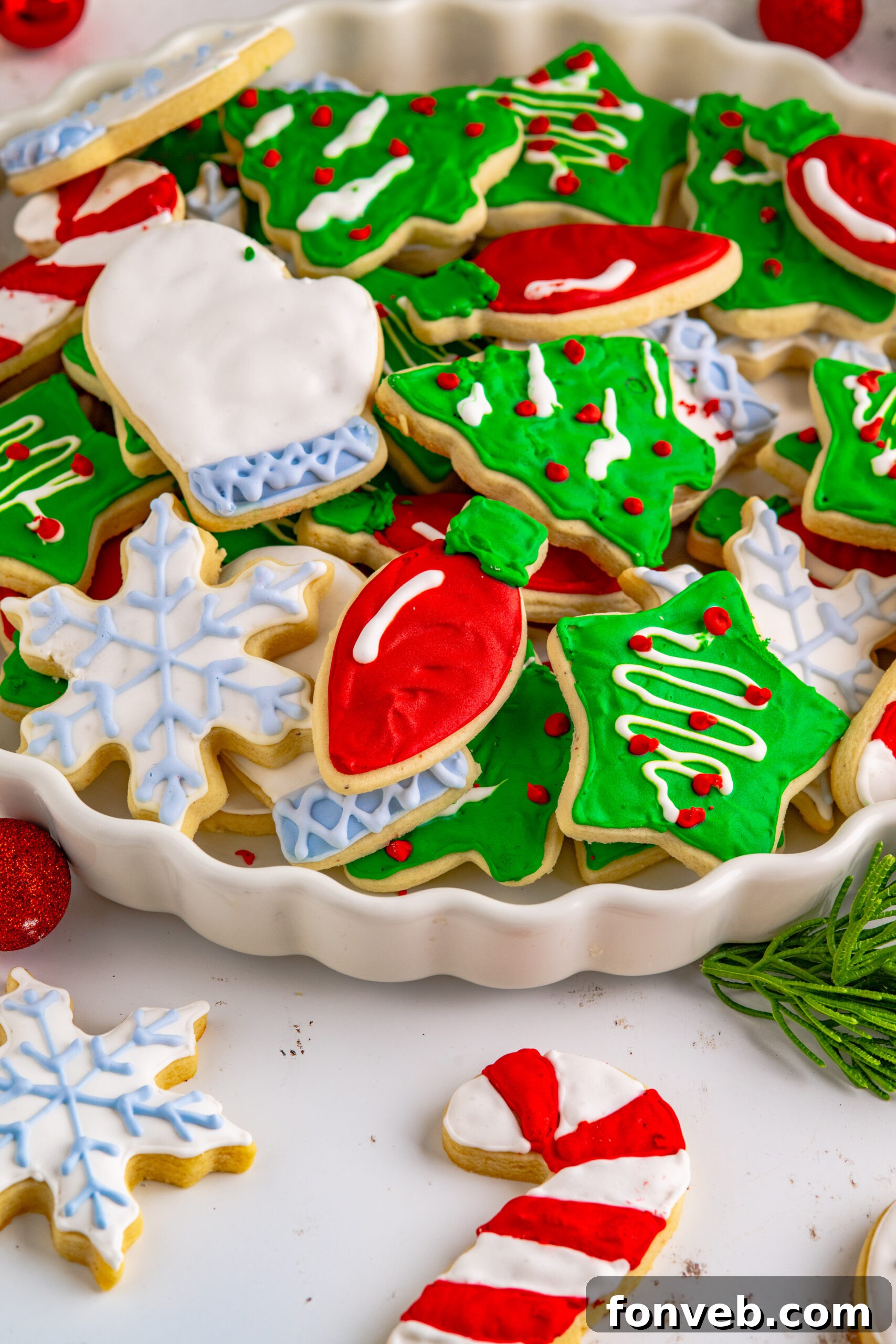 Christmas Sugar Cookies stacked on a white serving tray.