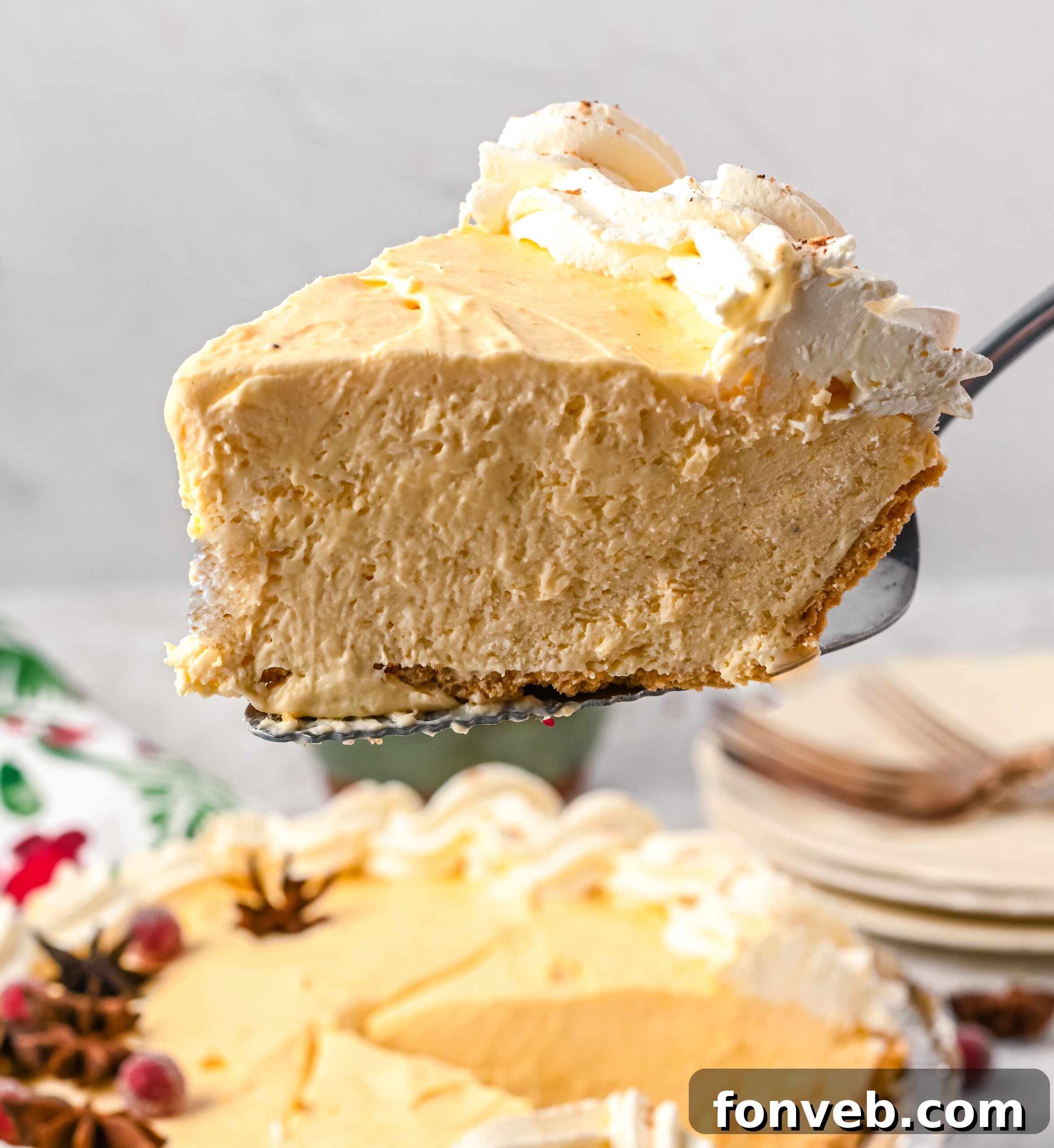A slice of eggnog pie being lift up on a pie spatula.