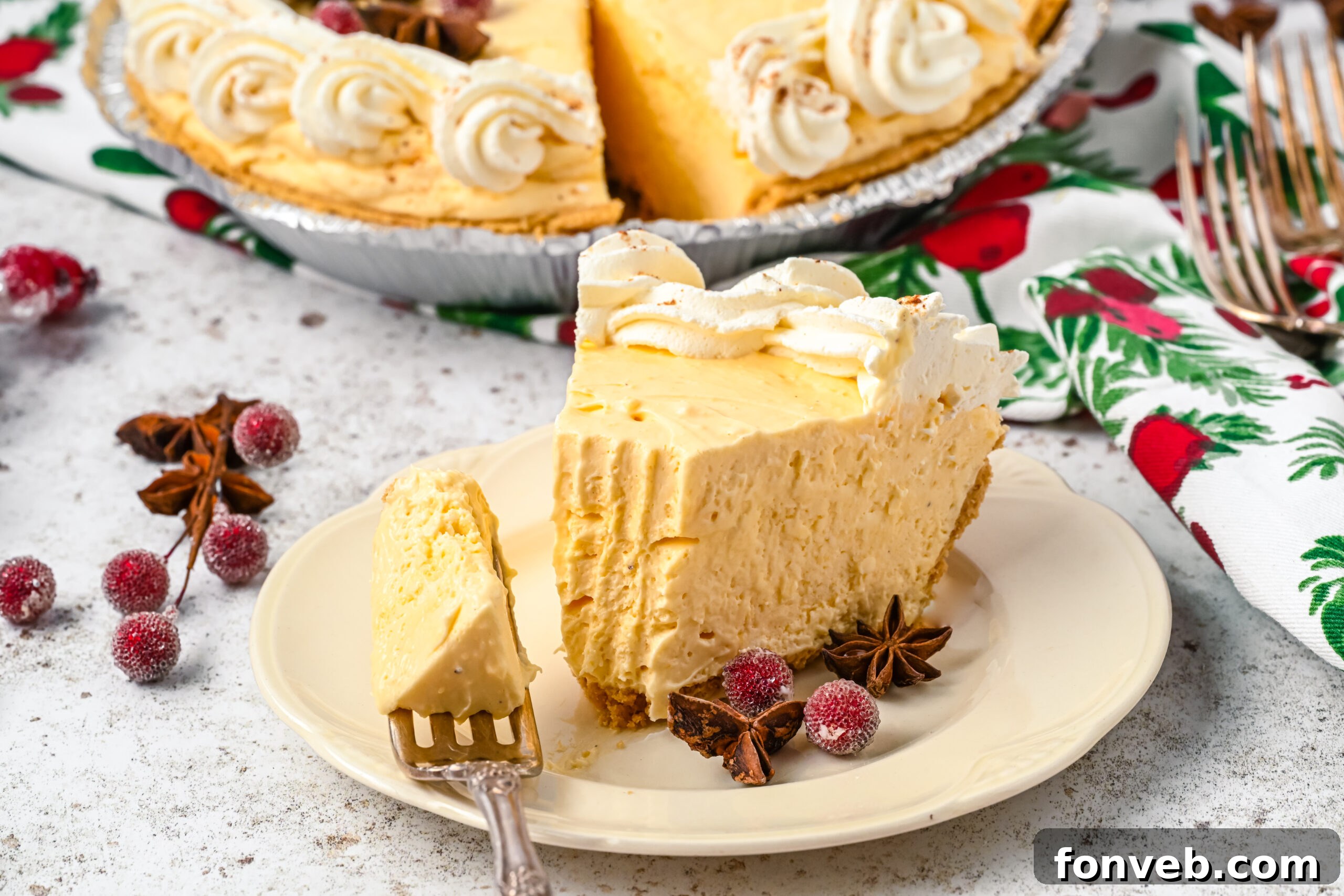 A piece of pie on a white dish with a silver fork removing a piece. 