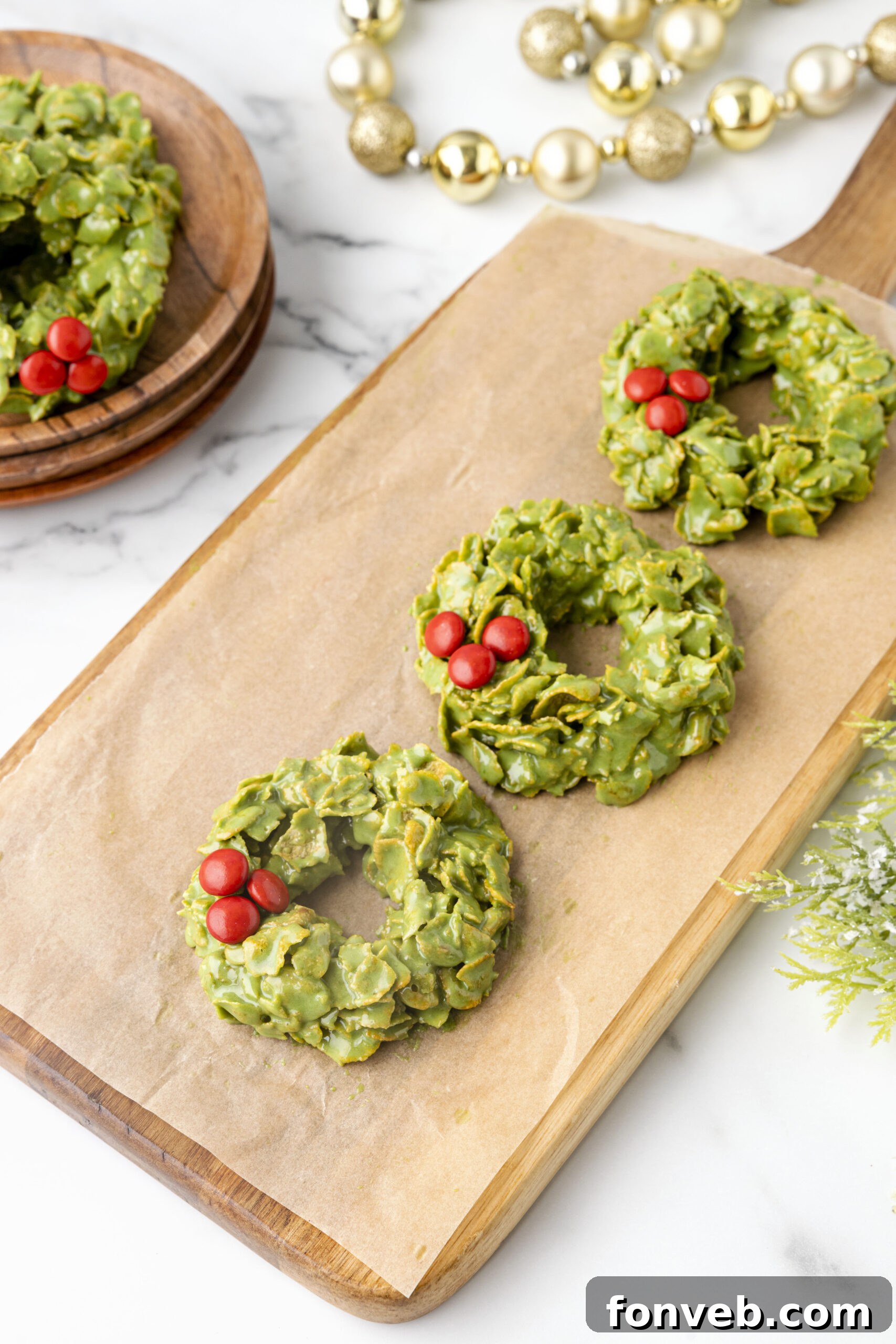 Three cornflake wreaths arranged artfully on a rustic wood serving tray, highlighting their homemade charm.