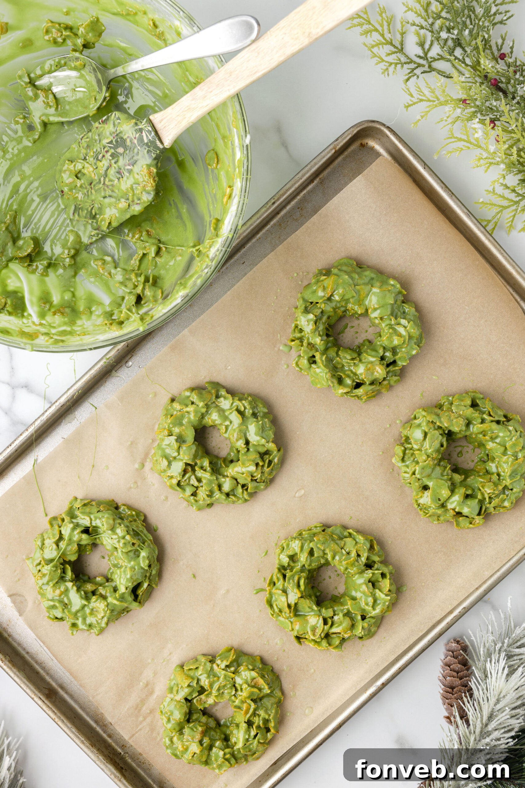 Step-by-step image of creating the center hole in a cornflake wreath using a finger.