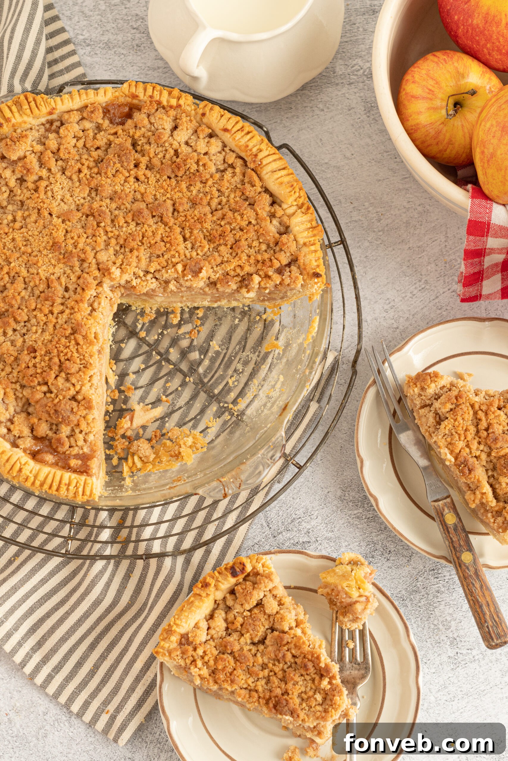 Golden Dutch Apple Crumb Delight 10 Overhead shot of the pie dish with pieces of pie removed onto tan plates.