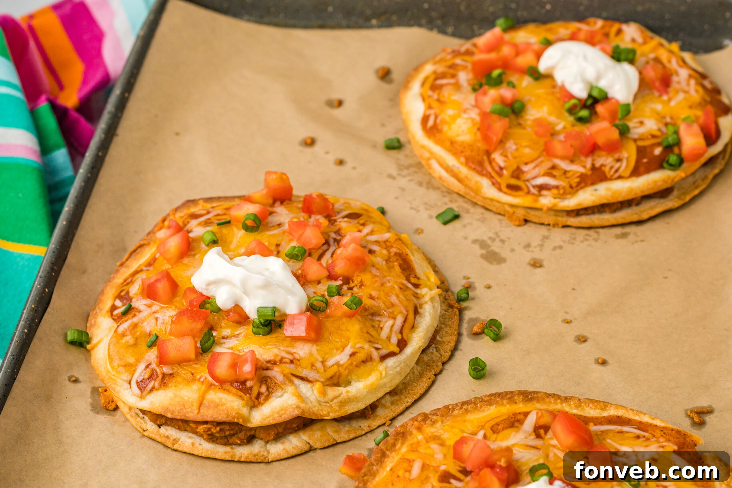 three mexican pizzas on brown paper lining a baking sheet