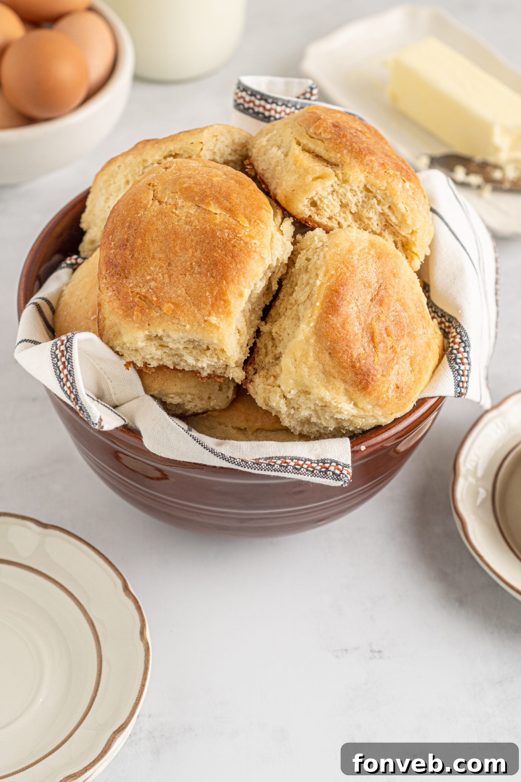 A rustic brown bowl filled with Angel Biscuits, elegantly presented on a white and black linen, capturing their home-baked appeal.