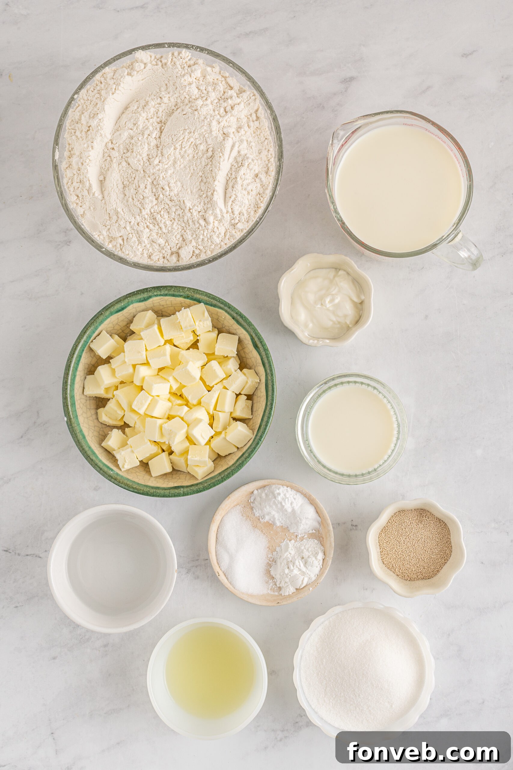 An organized overhead shot displaying all the fresh ingredients meticulously laid out for making Angel Biscuits, emphasizing readiness and detail.