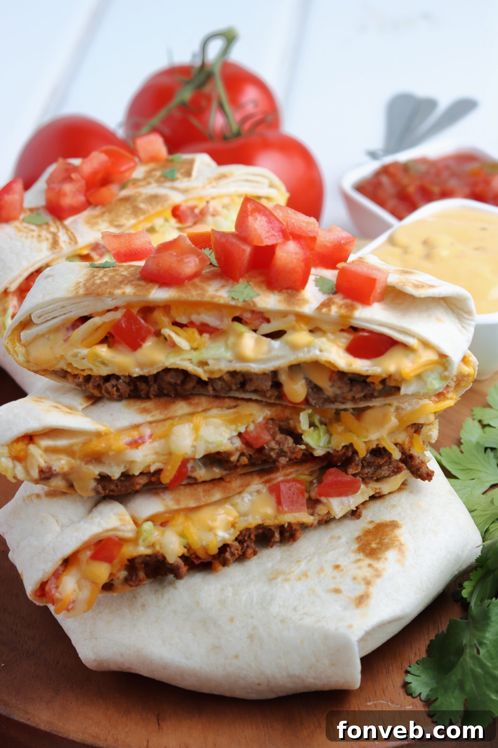 Ultimate Crispy Fold 2 Three crunch wraps cut in half and stacked on top of each other showing the layers on the inside. A perfect cross-section of flavor.