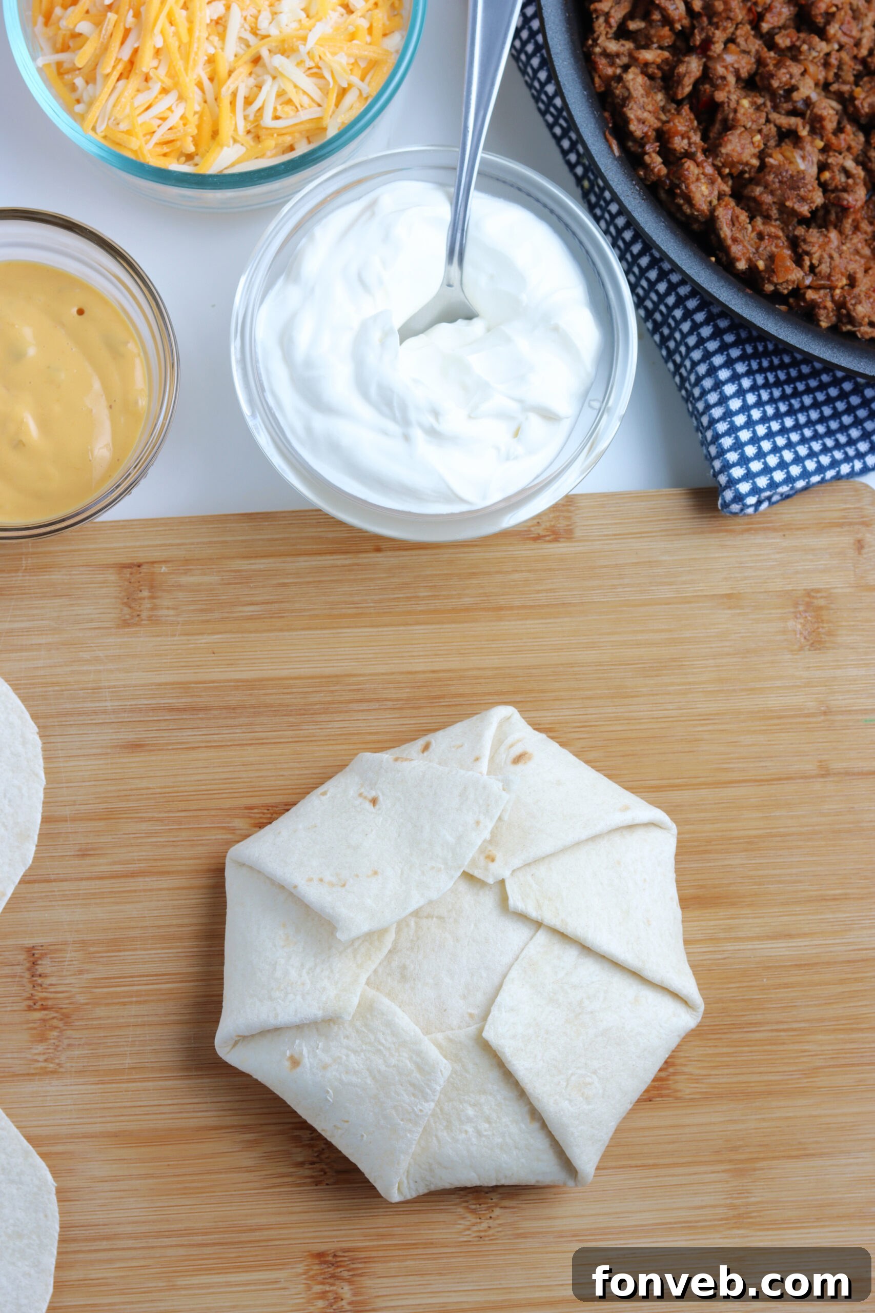 Ultimate Crispy Fold 11 A tostada shell being placed on the large flour tortilla, ready for the next layer.