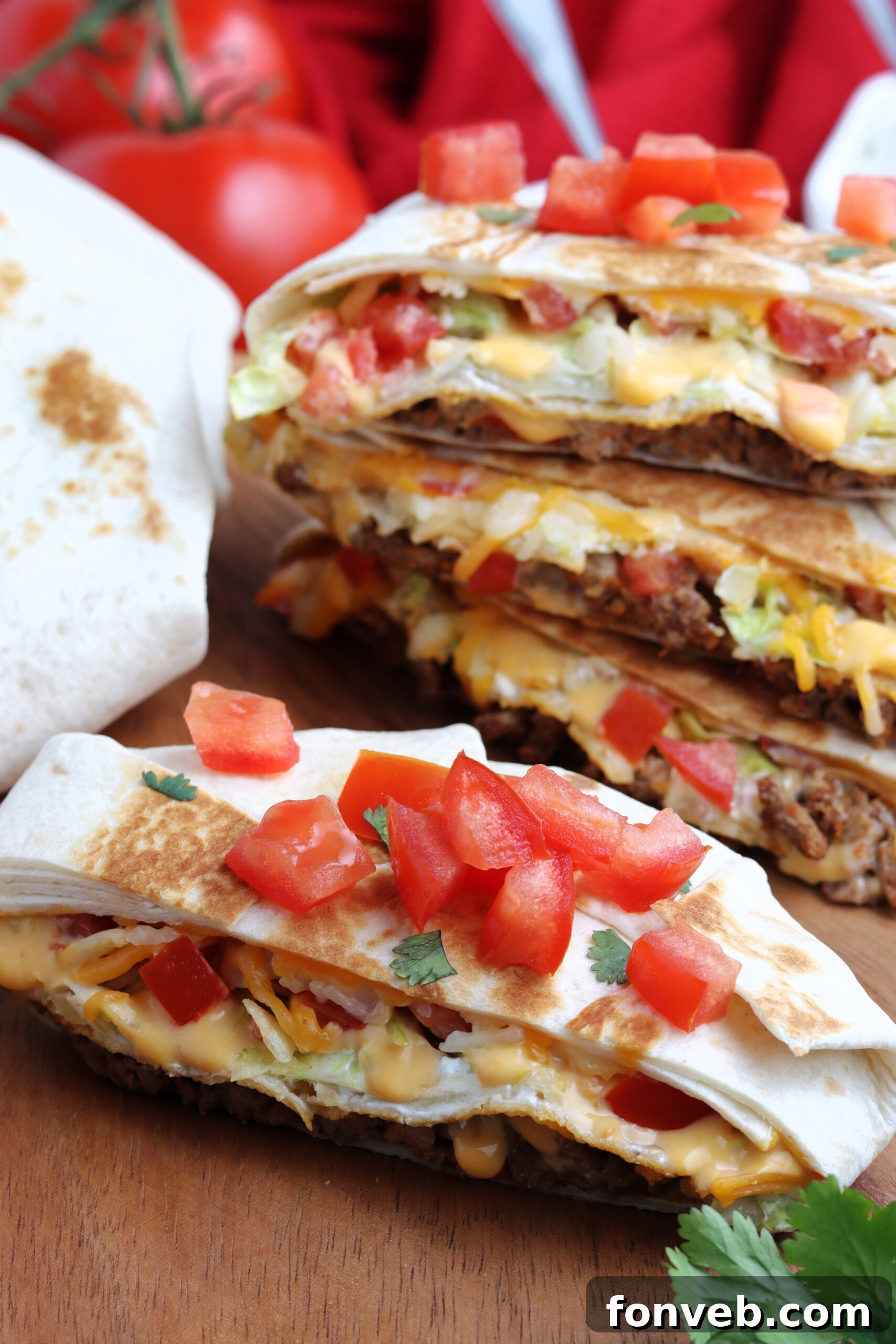 Ultimate Crispy Fold 5 Half of a crunch wrap on a wooden board, garnished with fresh cilantro and diced tomatoes for a vibrant presentation.