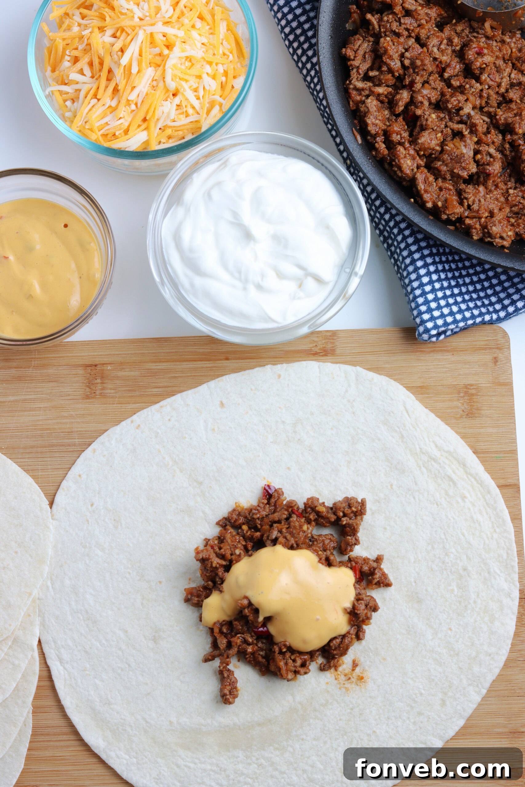 Ultimate Crispy Fold 8 Detailed shot of the assembly process, layering ingredients onto the tortilla.